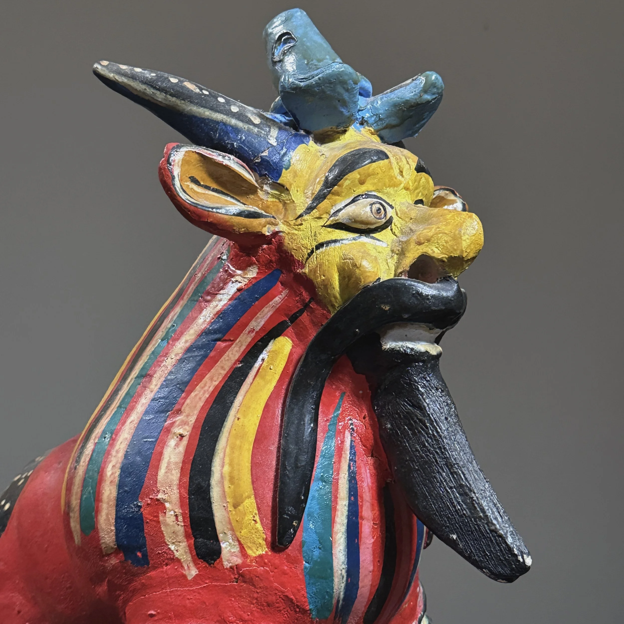 Close-up detail of hand-painted polychrome decoration on a Candelario Medrano fantastical creature sculpture