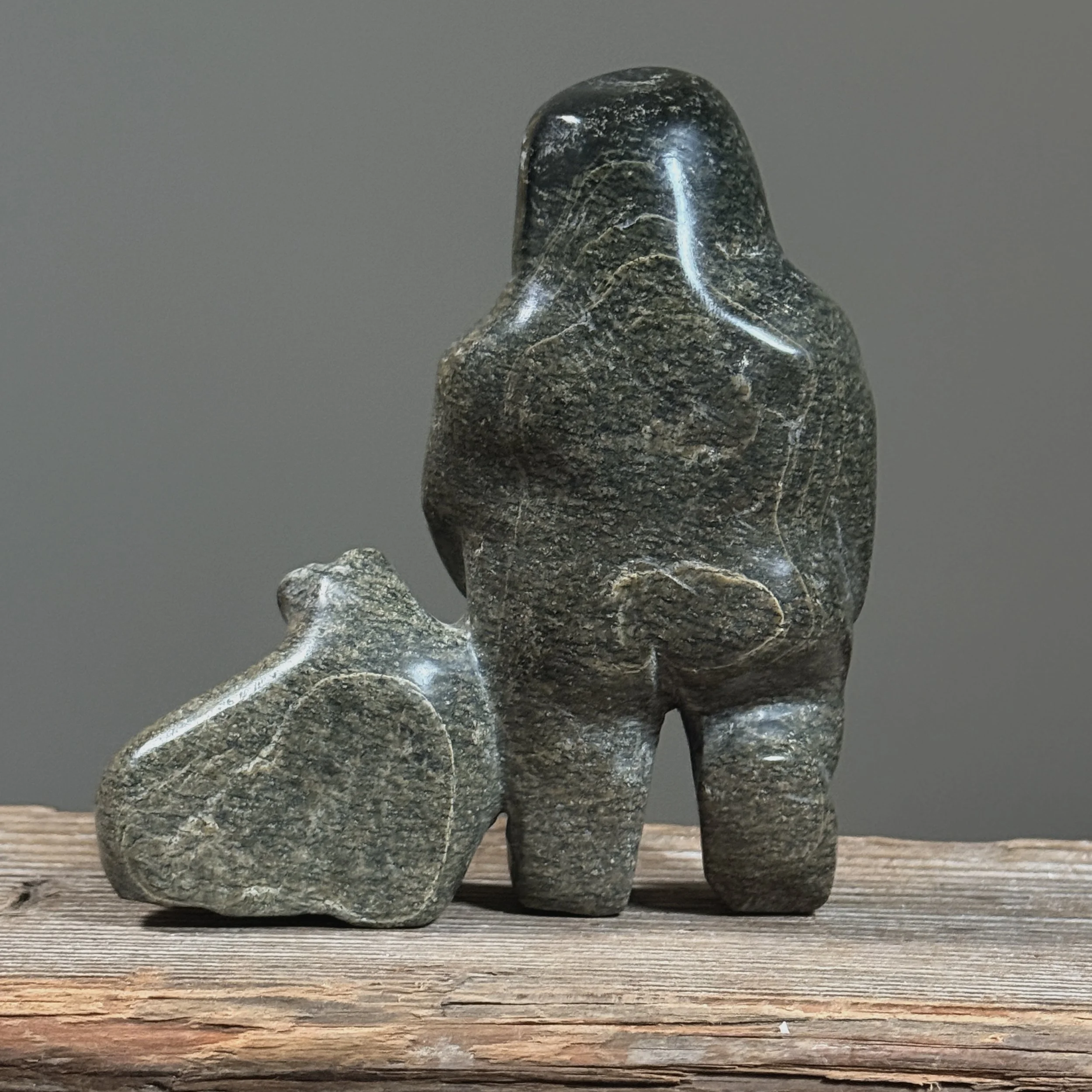 Rear view of a hand-carved Inuit sculpture demonstrating polish and surface texture