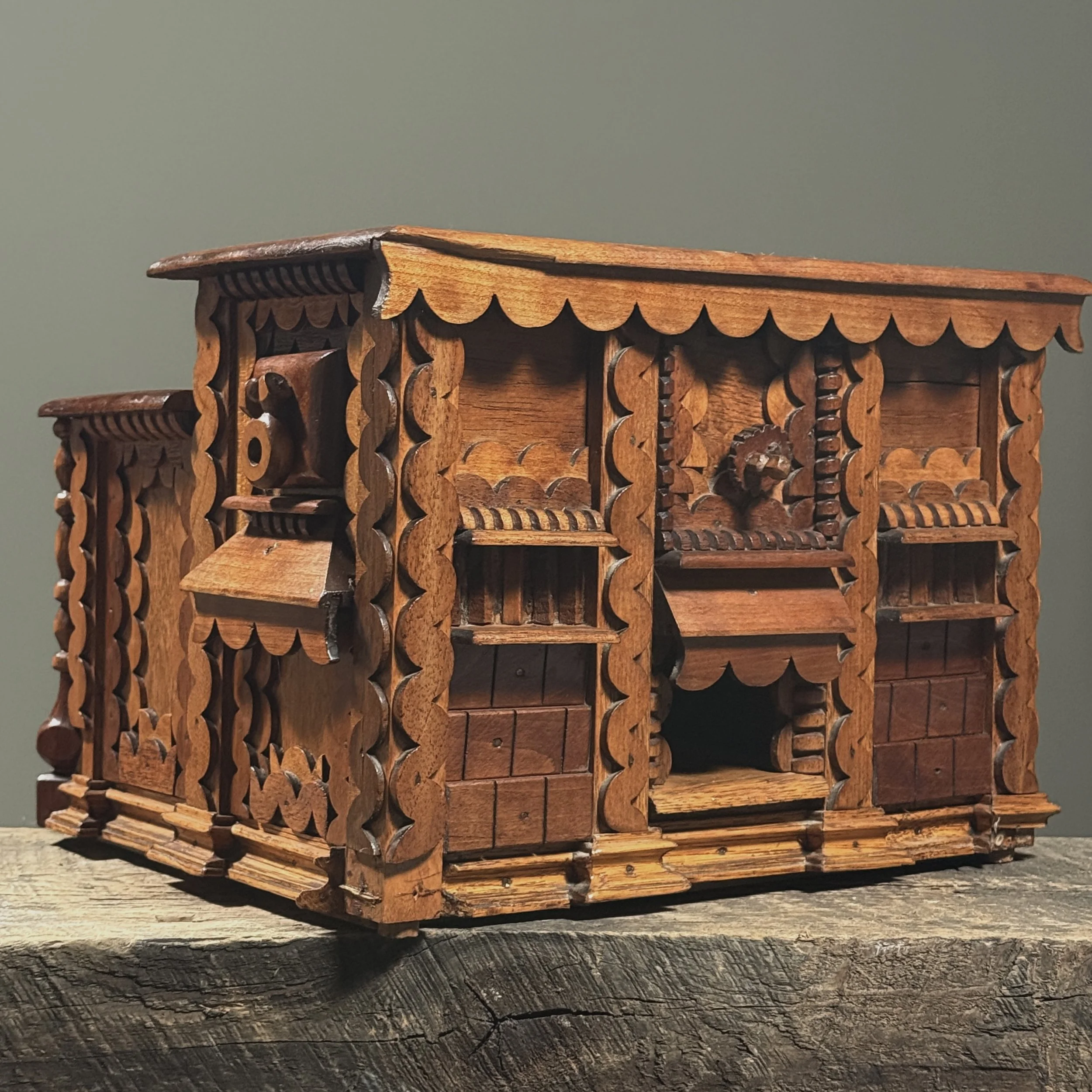 Three-quarter view of a heavily decorated scrollwork box featuring five front drawers and side drawers