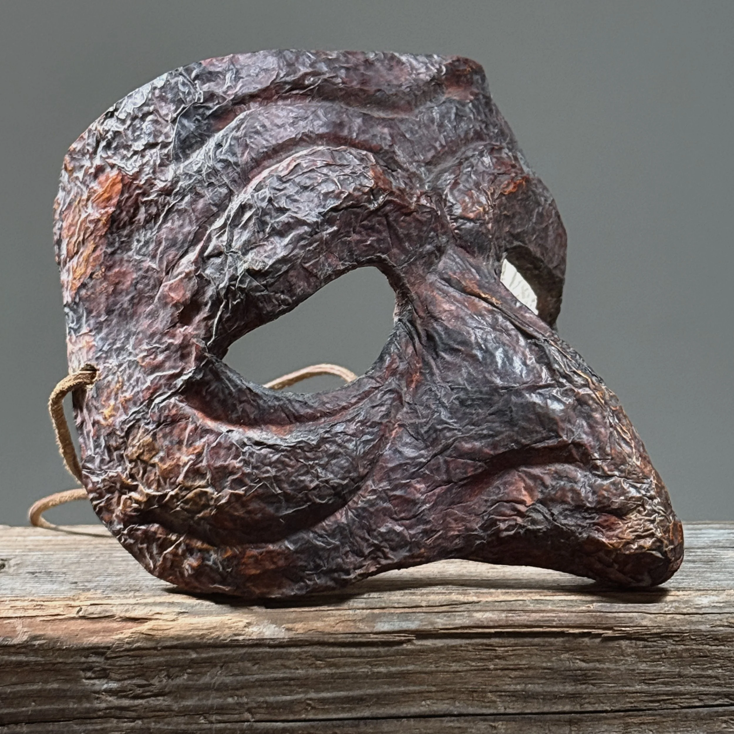 Front view of deep red papier-mâché Commedia Harlequin mask.