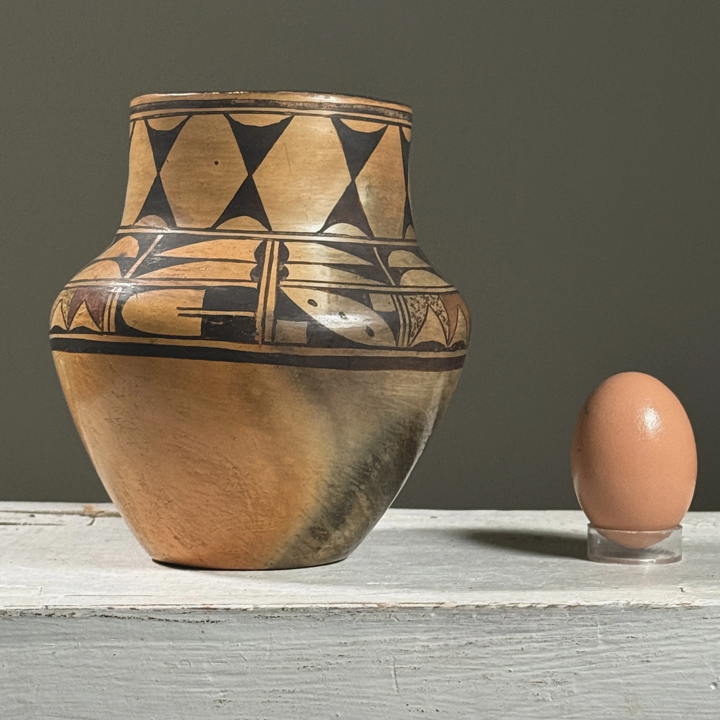 Vintage Hopi polychrome clay vessel with elongated rim, unsigned With egg for size reference.