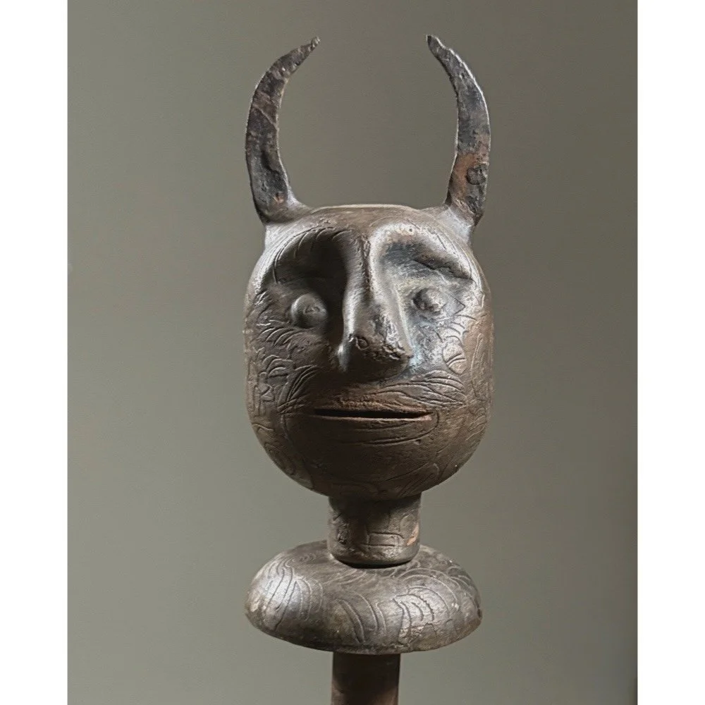 Close-up of forged devil face mace head showing etched features and dark patina.