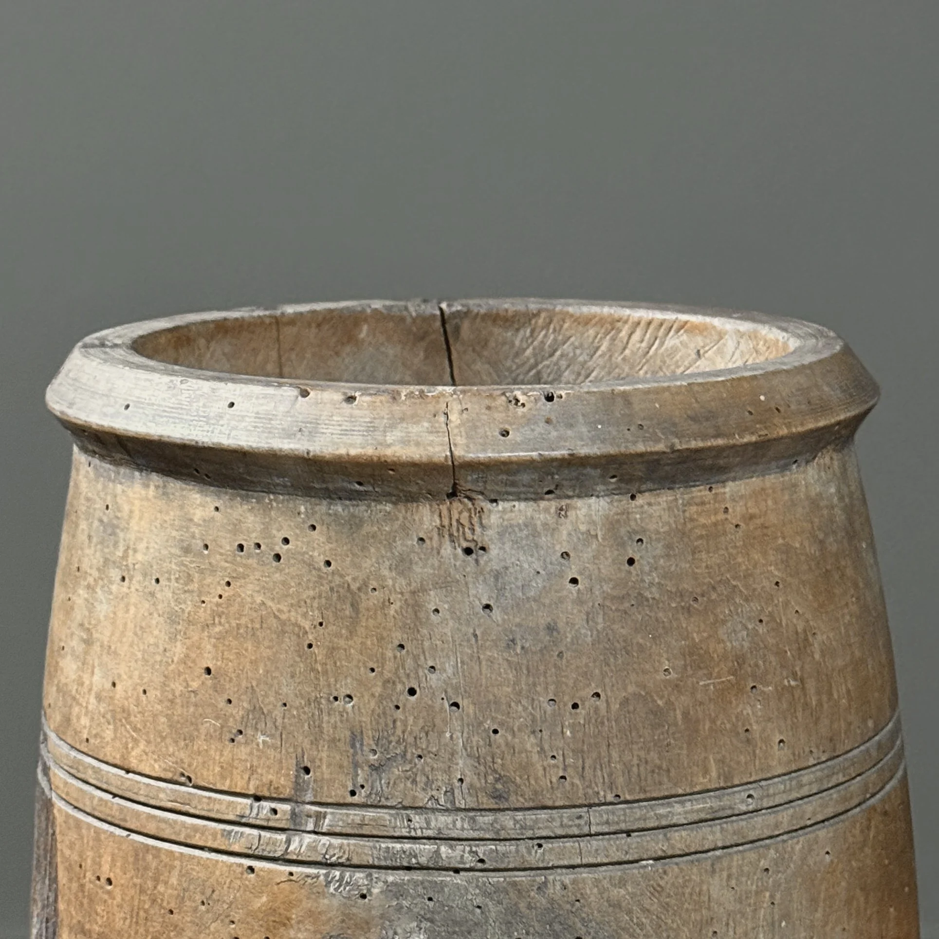 Front view of antique treenware barrel with concentric ribbed bands