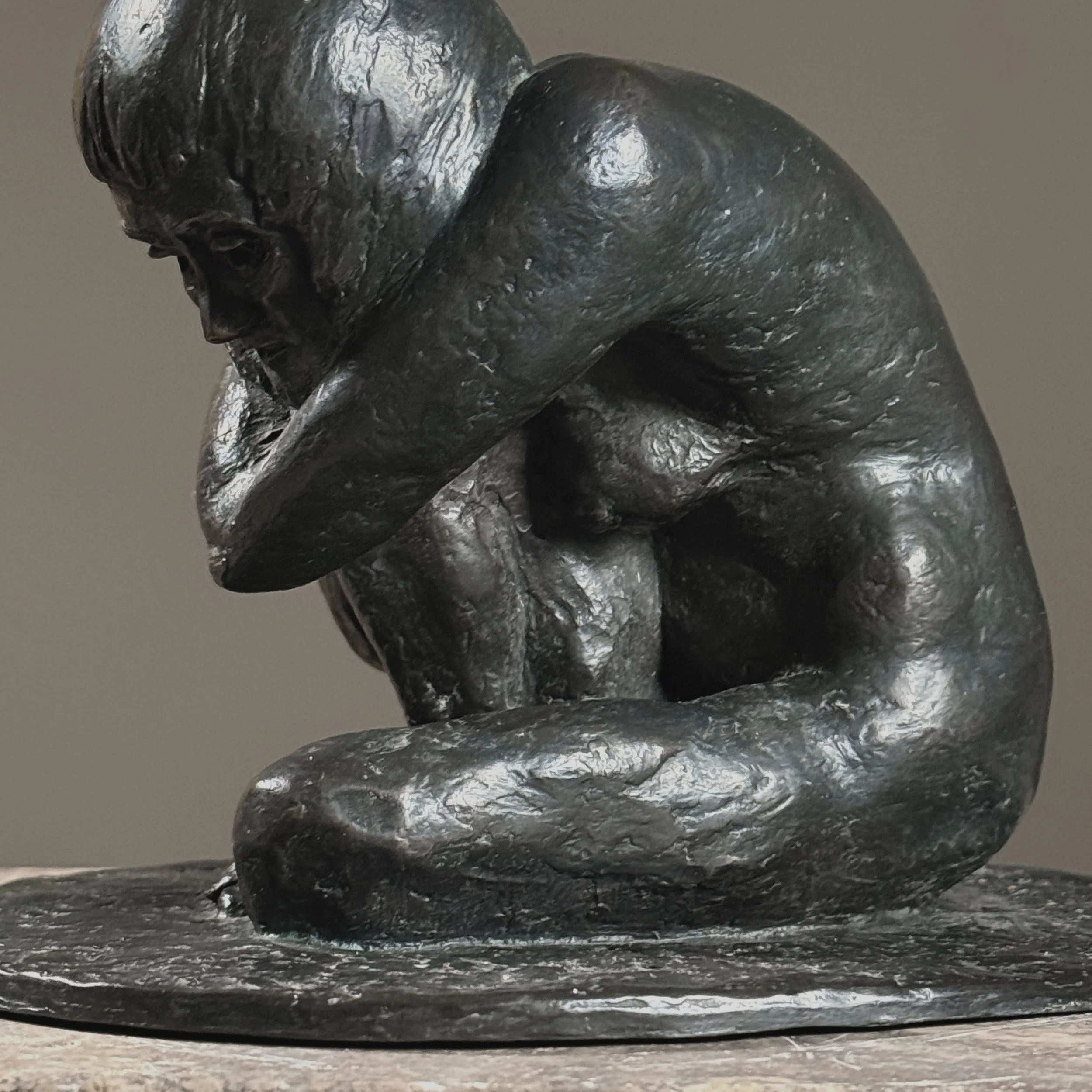 Close-up detail of the crouching nude's form and naturalistic anatomical modeling