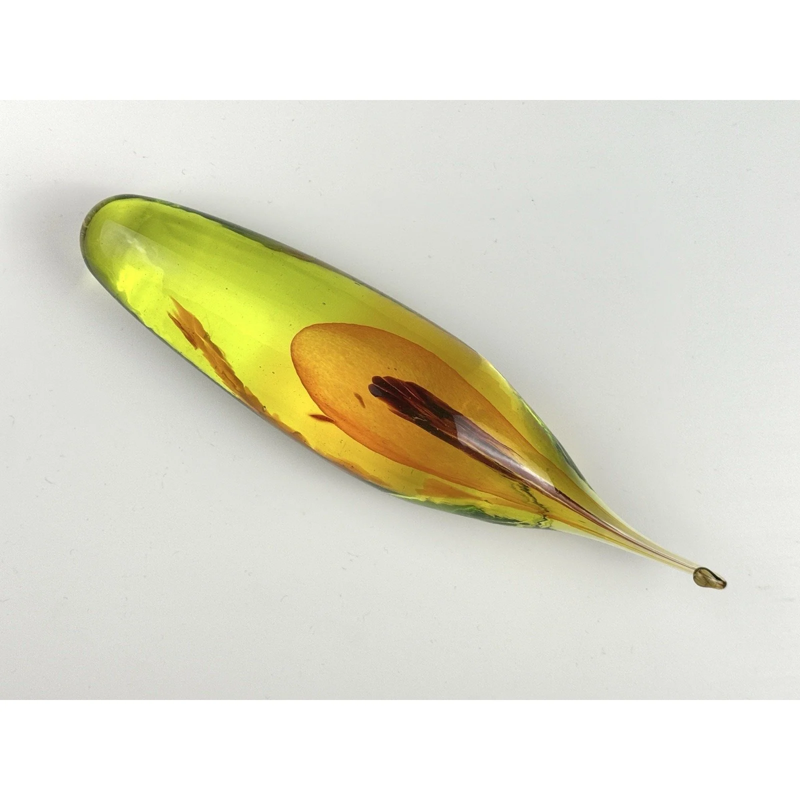 View of glass sculpture from front, capturing amber yellow seed