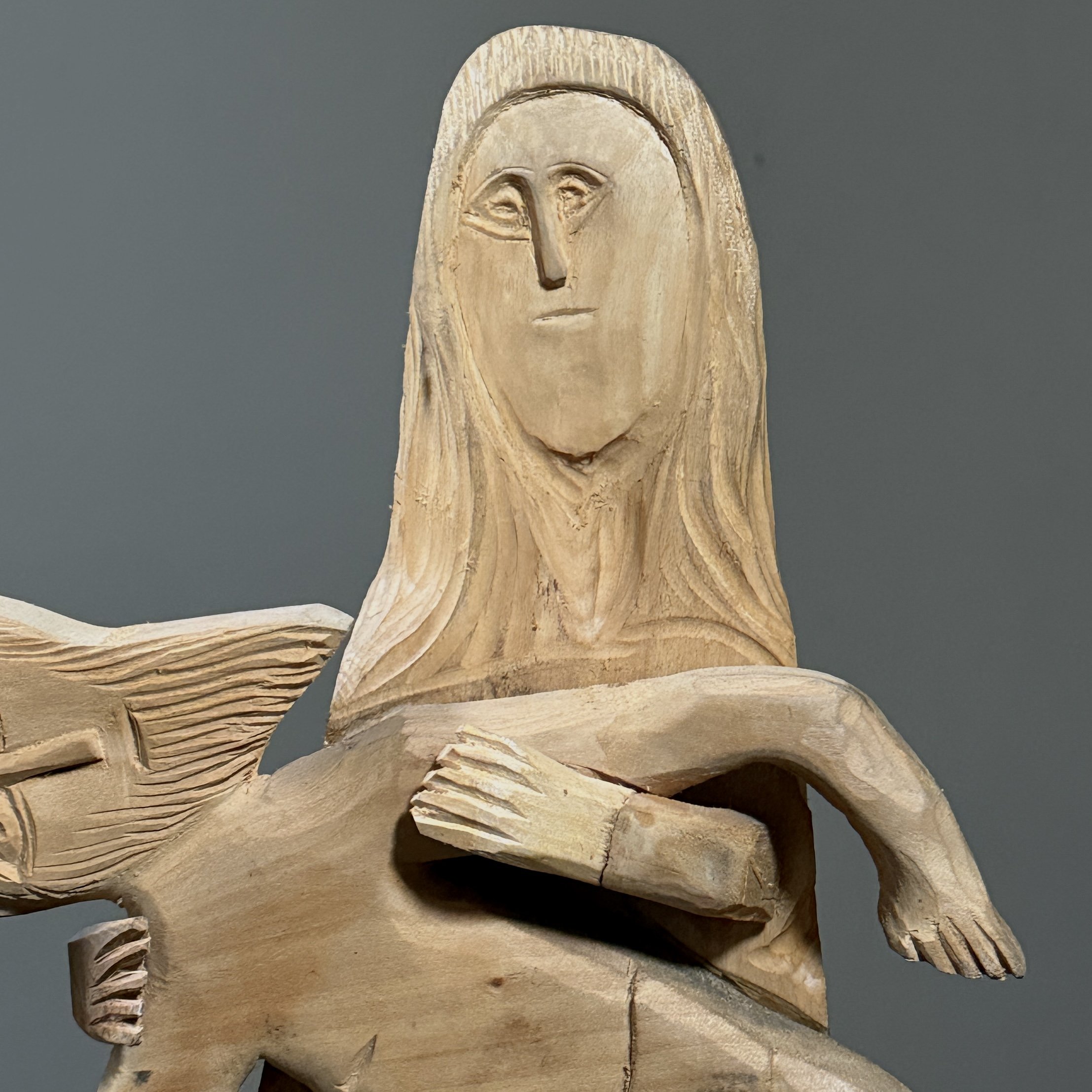 Close-up of the wood grain and carving tool marks on the surface.