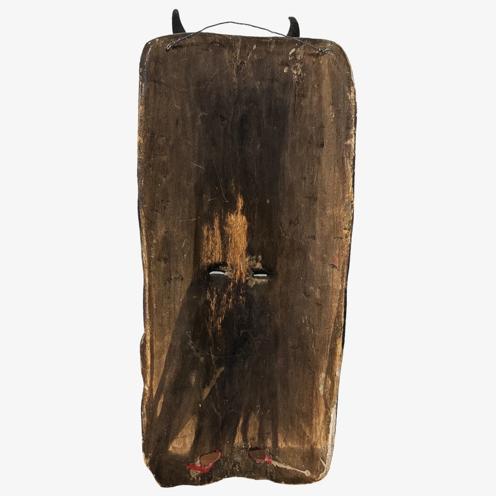 Rear view showing the wooden back, carving marks, and attached hanging wire.