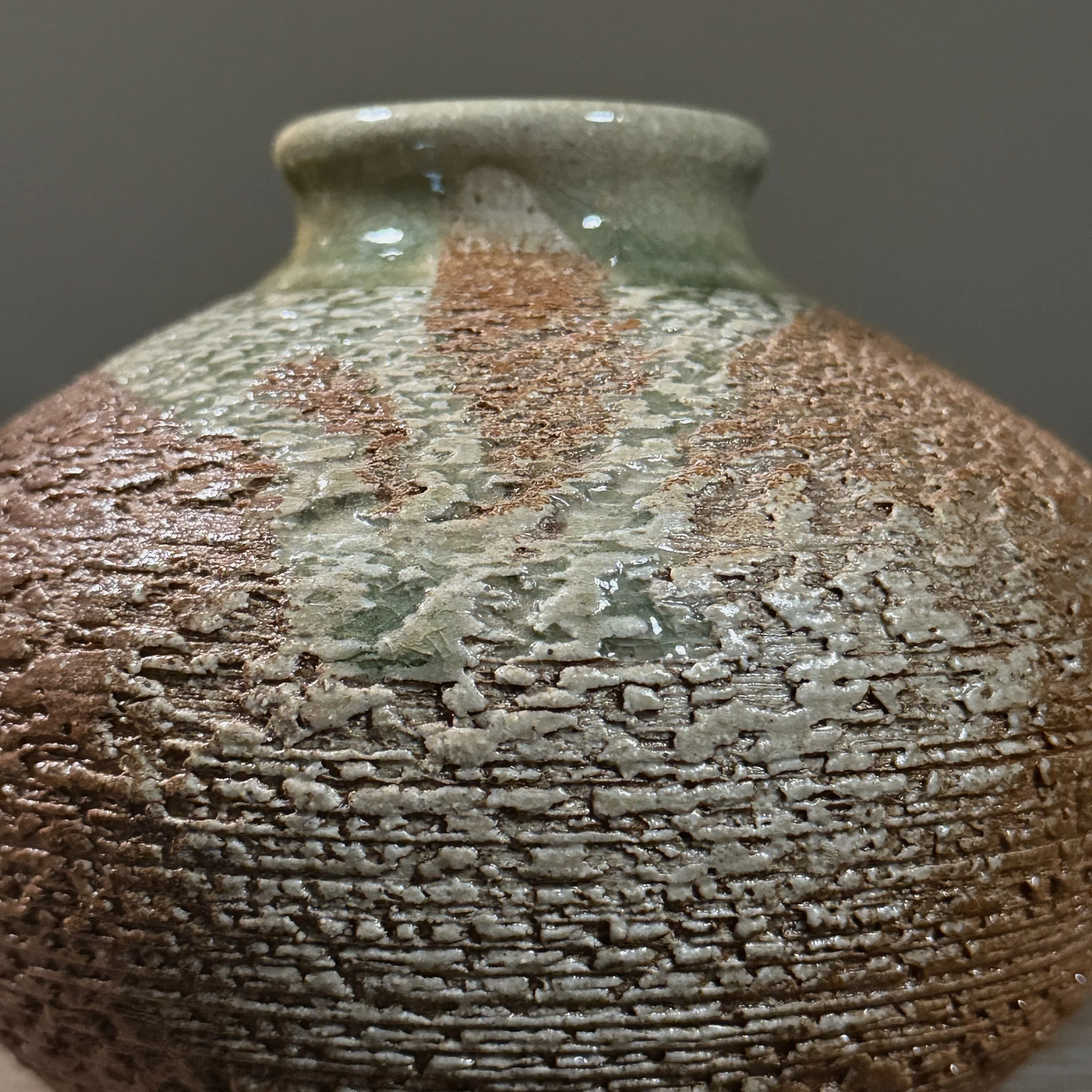 Detail of the vase's rim showing the celadon glaze drip on the exterior.