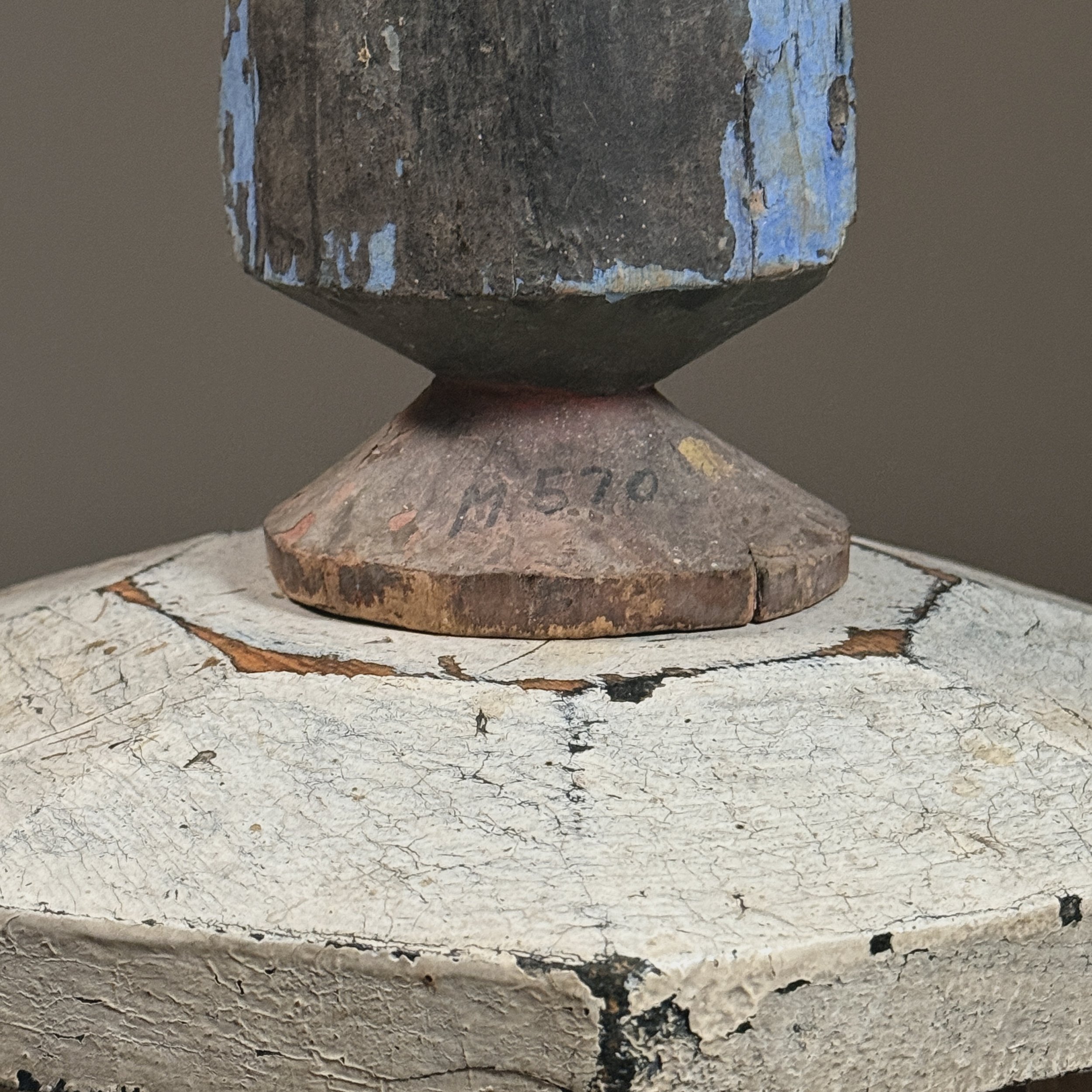 A view of the sculpture's base, showing its tapered form and wear patterns from handling.
