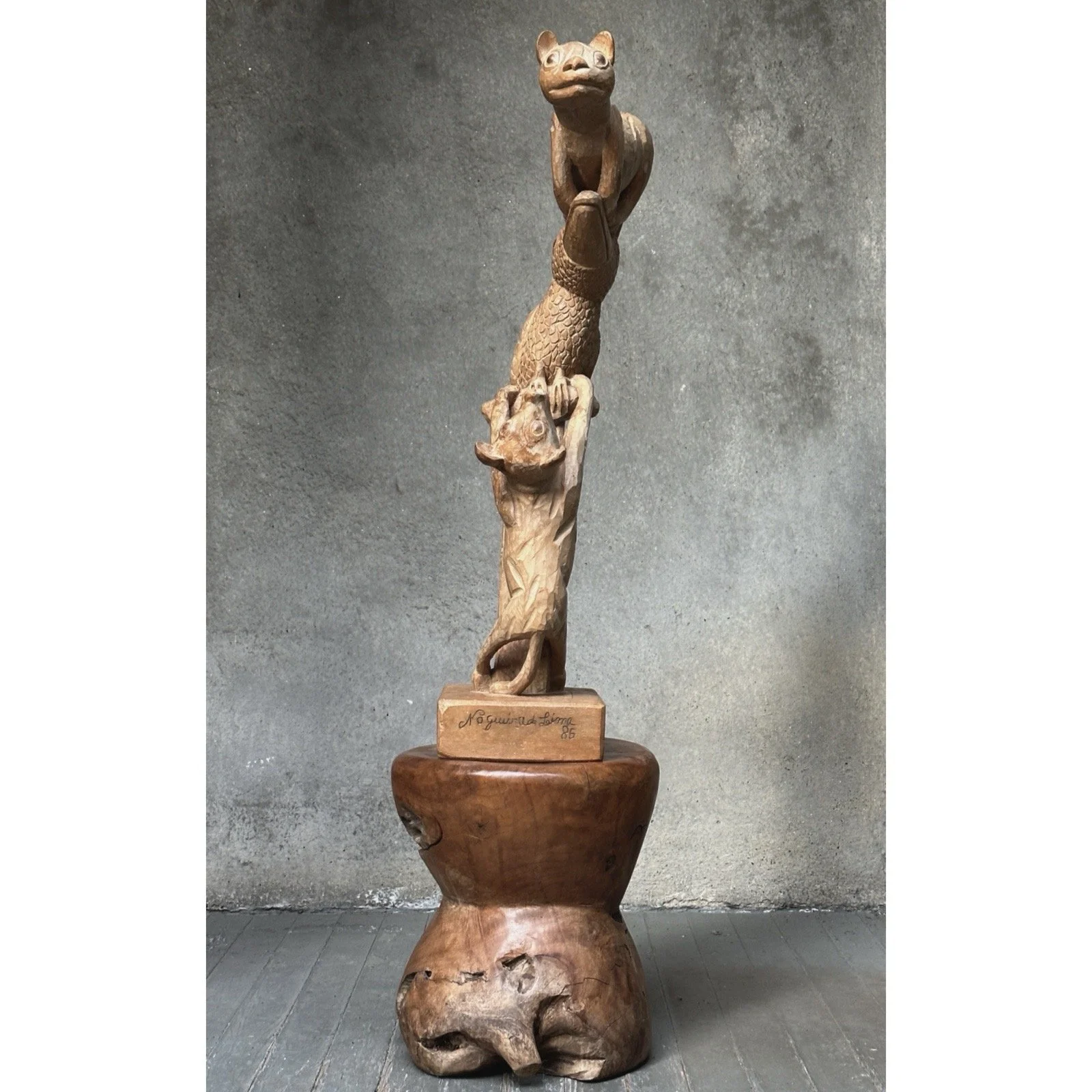 Full view of a Brazilian carved wooden folk art sculpture featuring a cat, dog, and toucan.