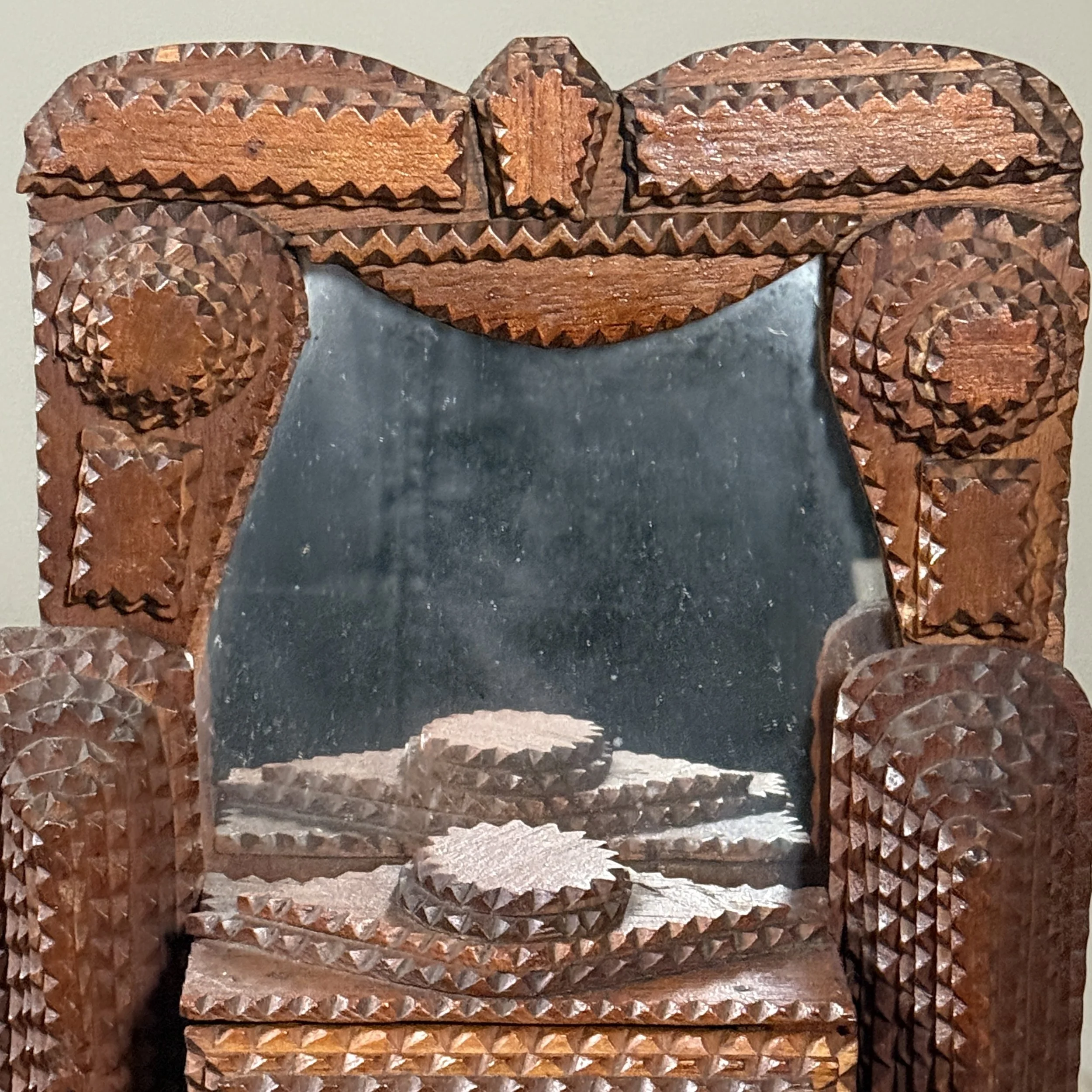 Detail of the framed mirror and its carved surround.