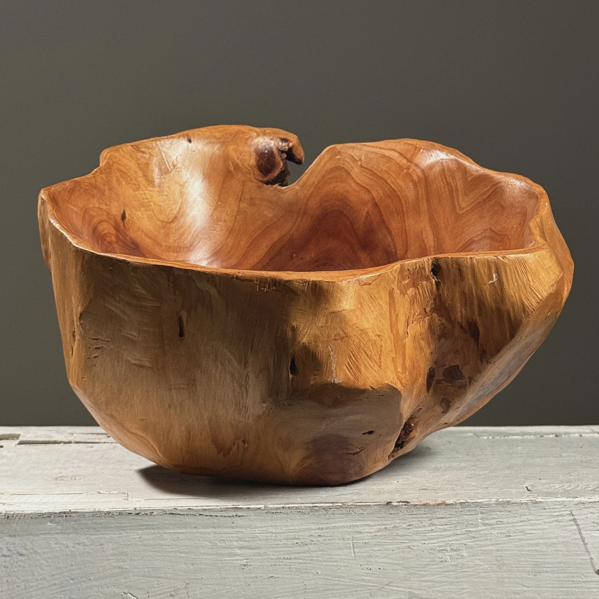 Full frontal view of a vintage hand-carved modernist root bowl with live edge exterior