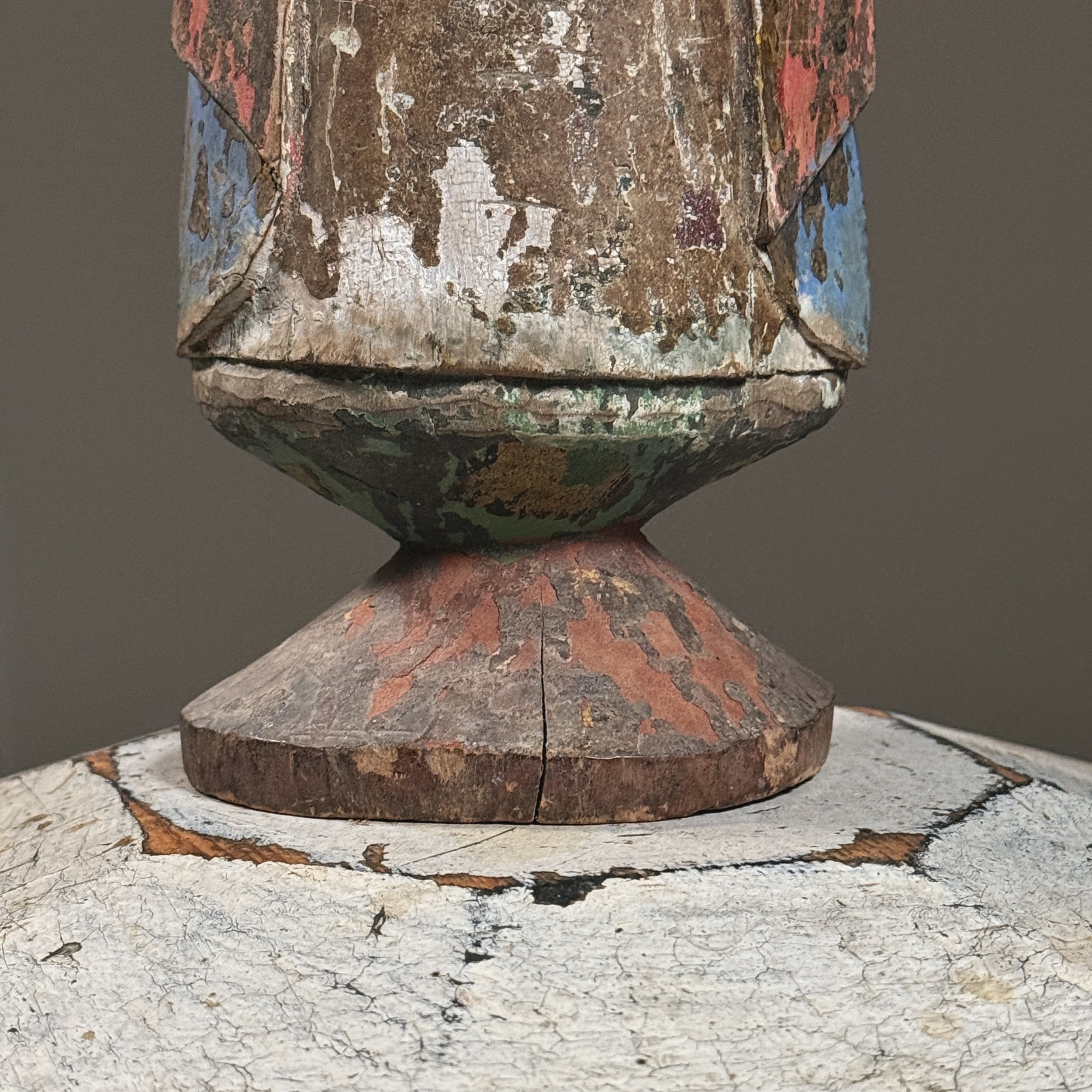 A view of the sculpture's base, showing its tapered form and wear patterns from handling.