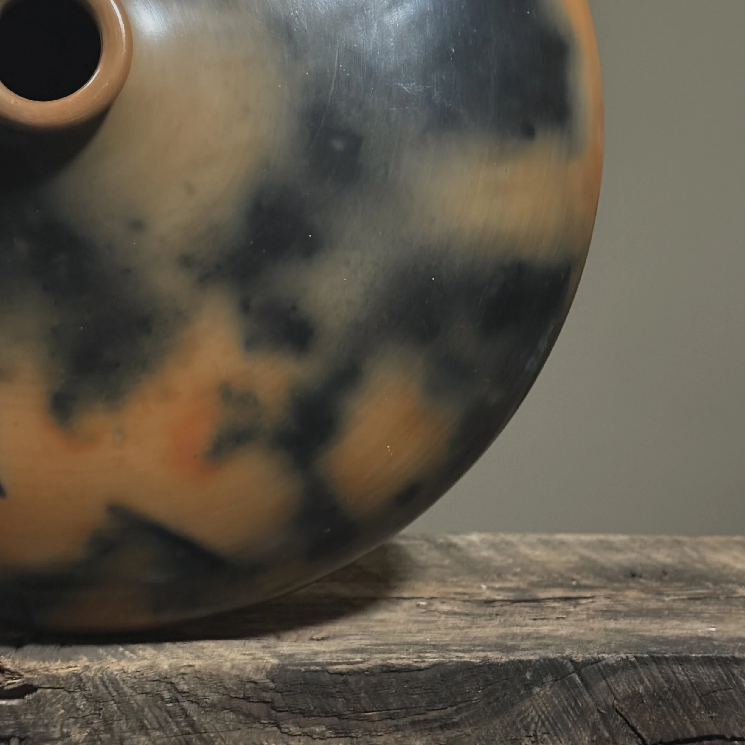Large round seed pot with mottled orange and black firing effects.