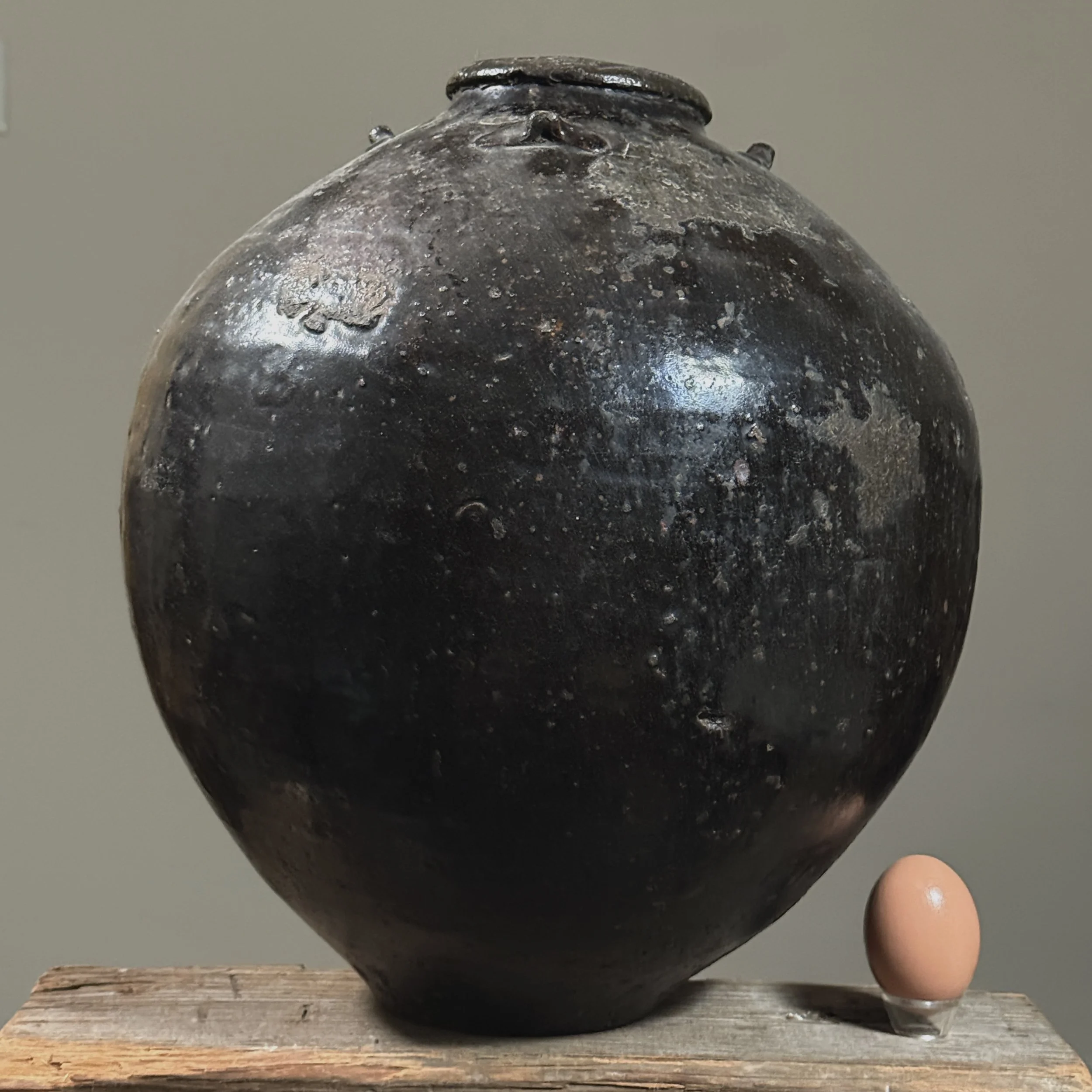 Full view of 17th century black-glazed ceramic storage vessel With egg.