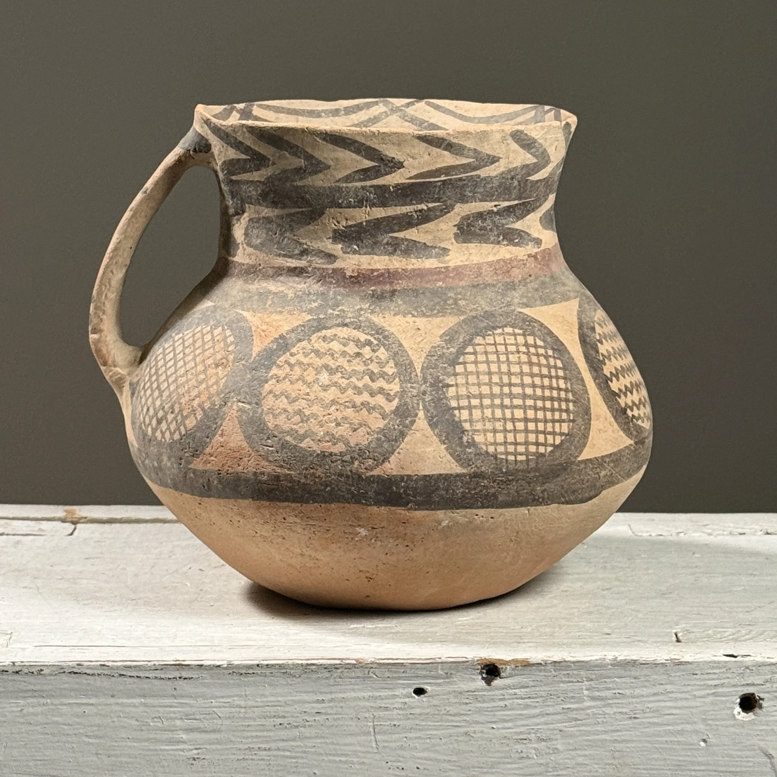 Full frontal view of a Chinese Neolithic style pottery jar with bulbous body and flaring neck
