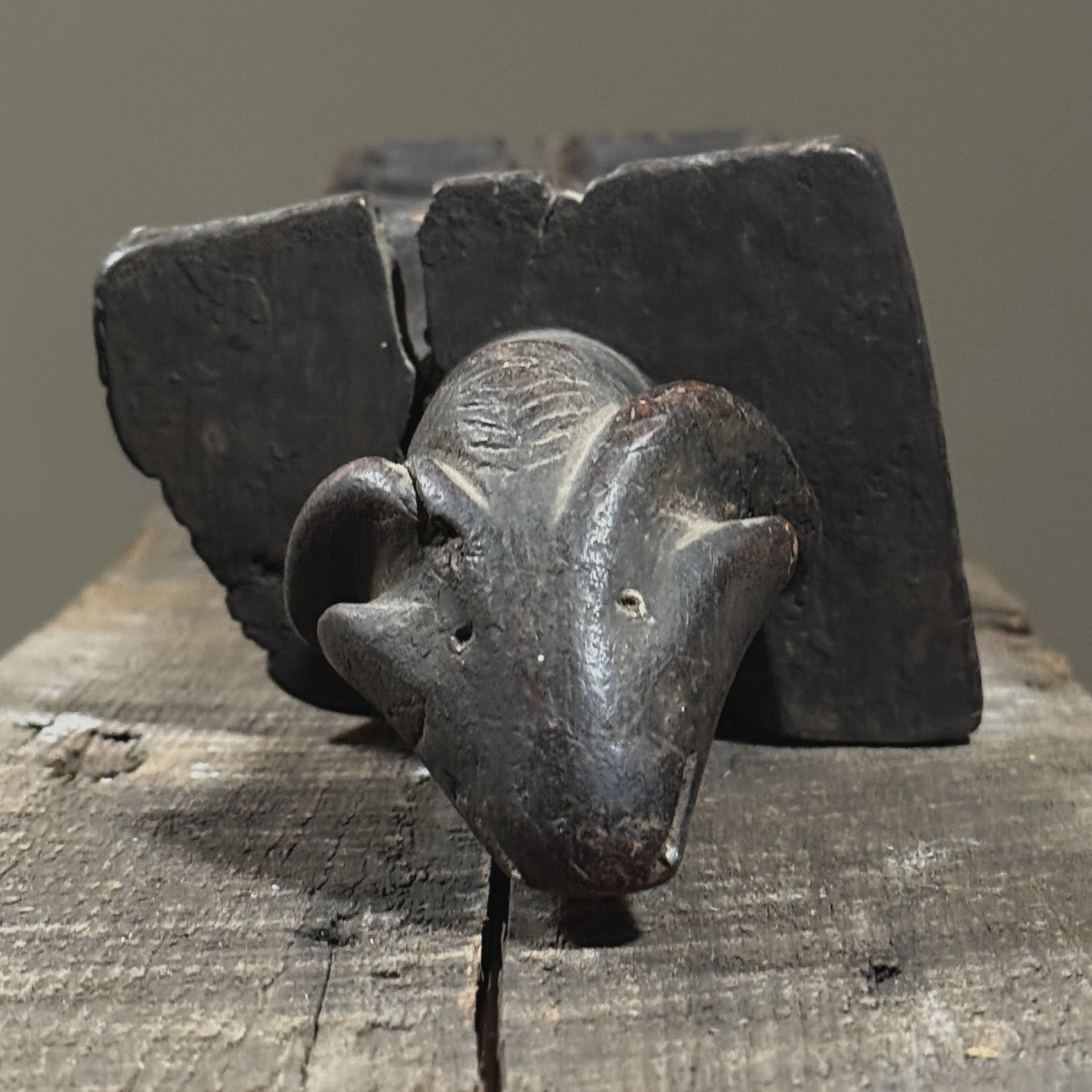 Close-up of geometric carving on side of antique African mancala board