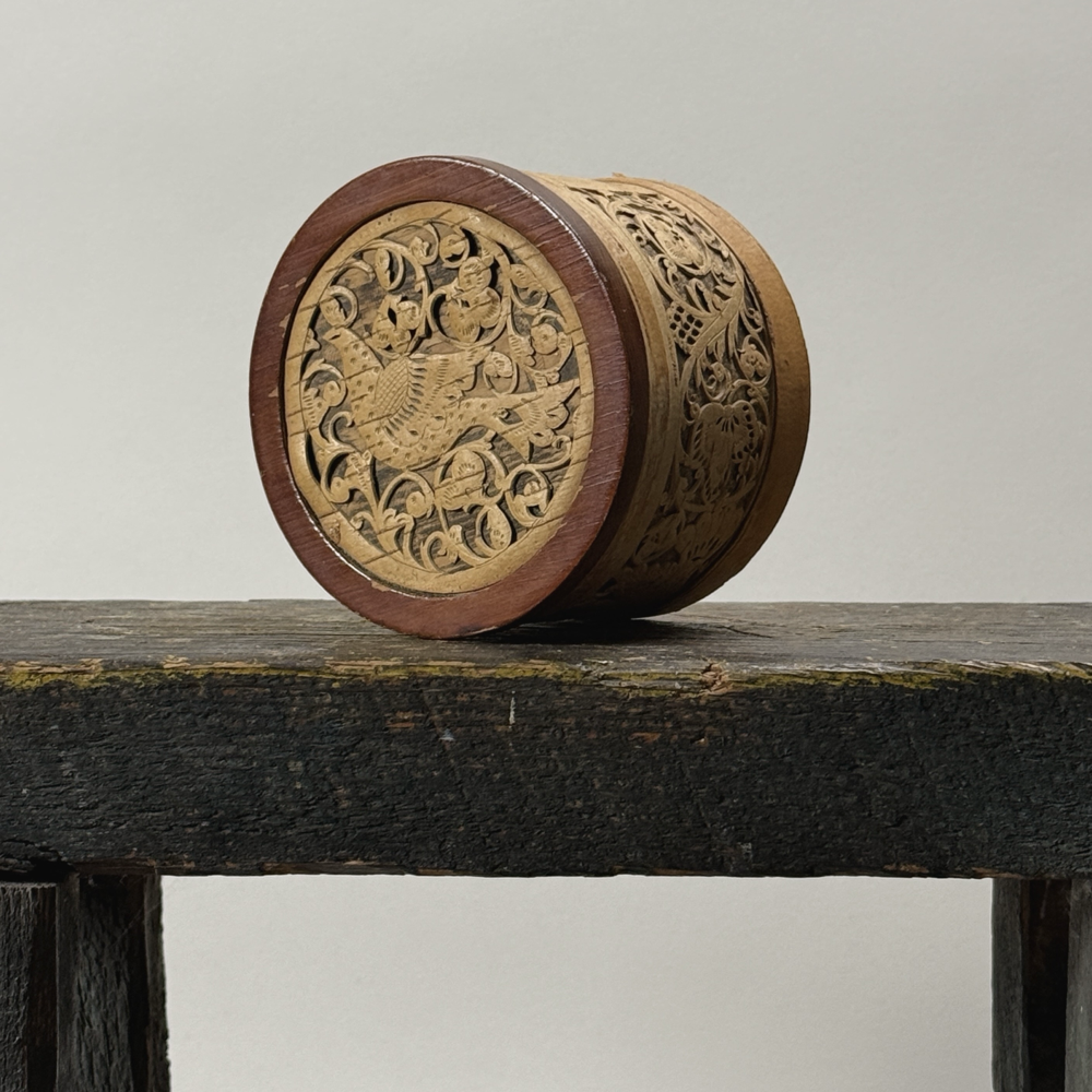 Front view of hand-carved birch bark lidded box with bird motif on lid