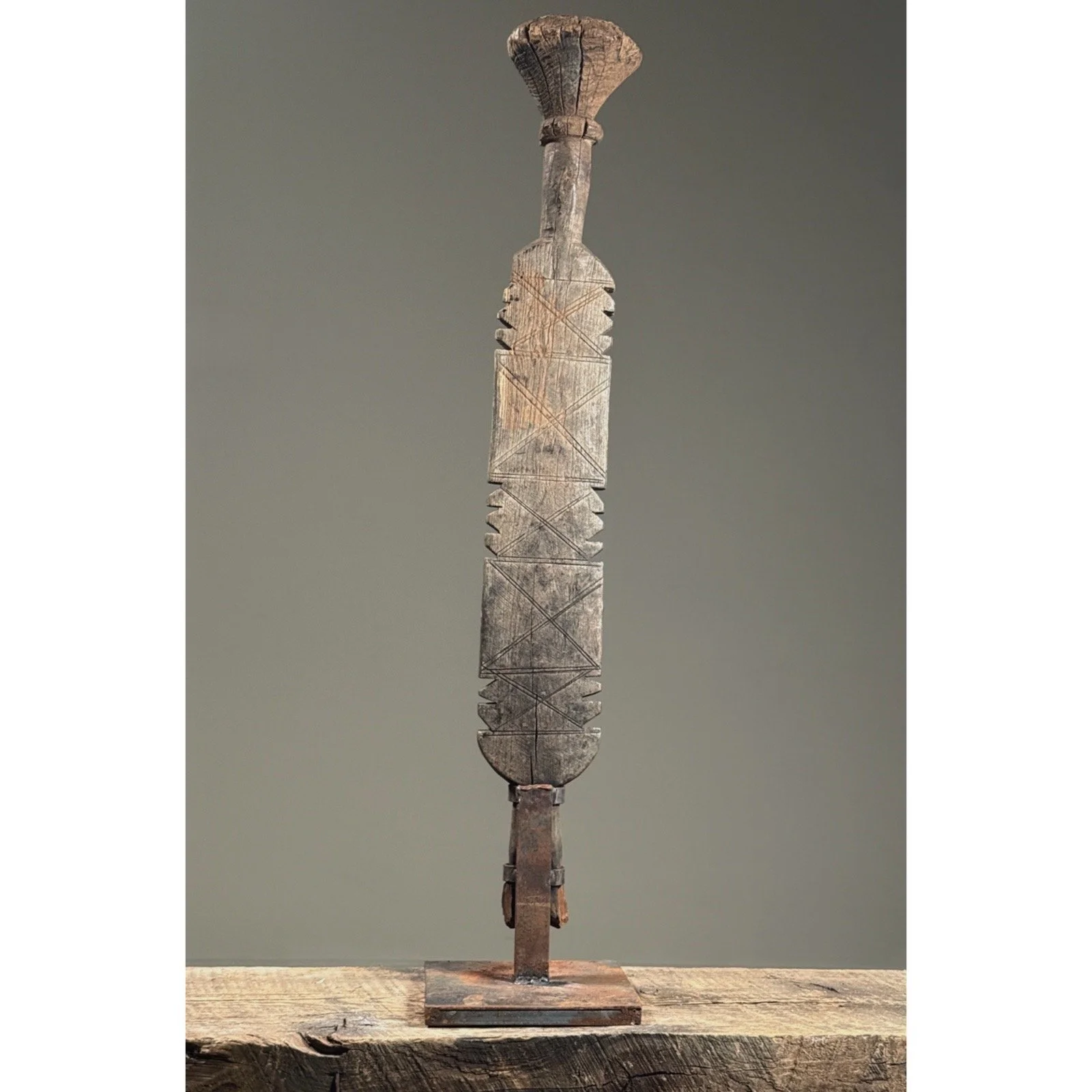 Full view of an antique Tuareg hand-carved wooden tent pole on custom iron stand.