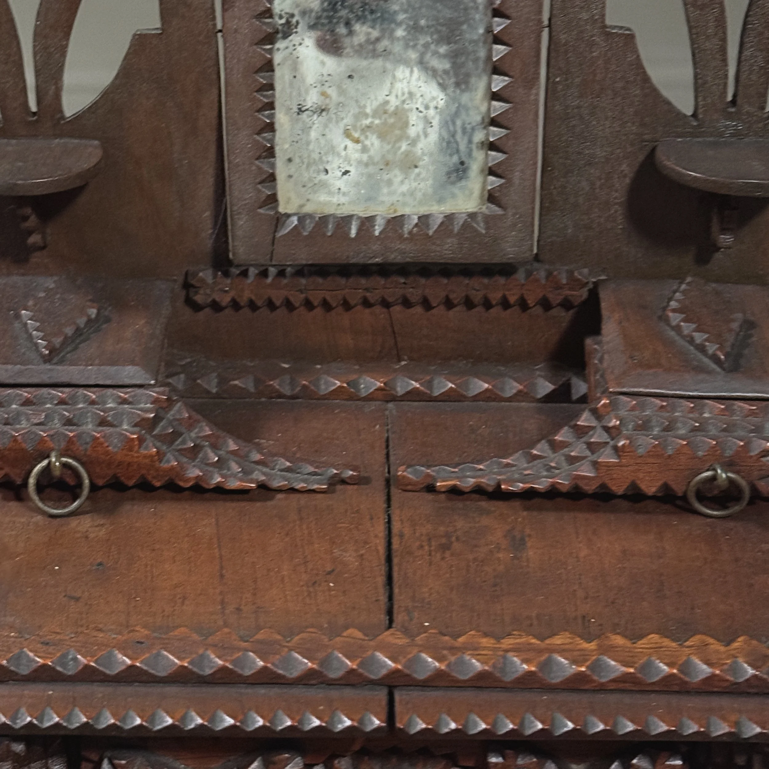 Winged upper drawers flanking the mirror on tramp art dresser