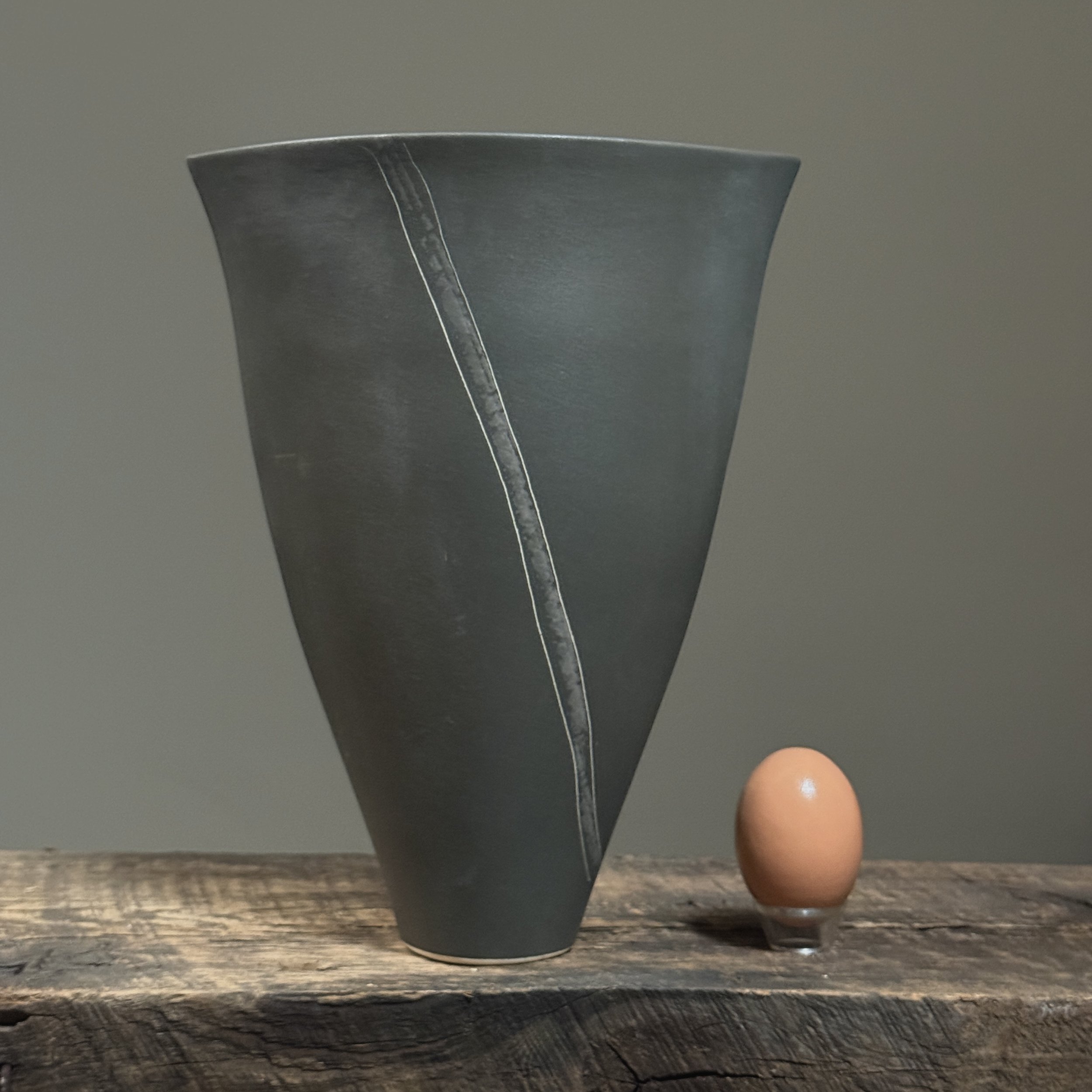 Vintage Postmodernist Japanese black matte porcelain ikebana vase with egg for size reference.