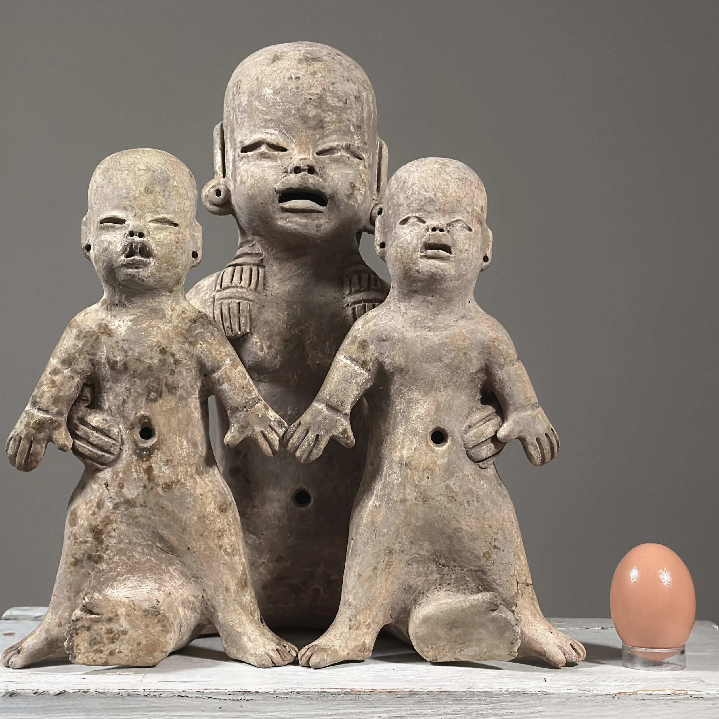 Antique Olmec style folk art baby sculpture, three terracotta figures, wood fired With egg for size reference.