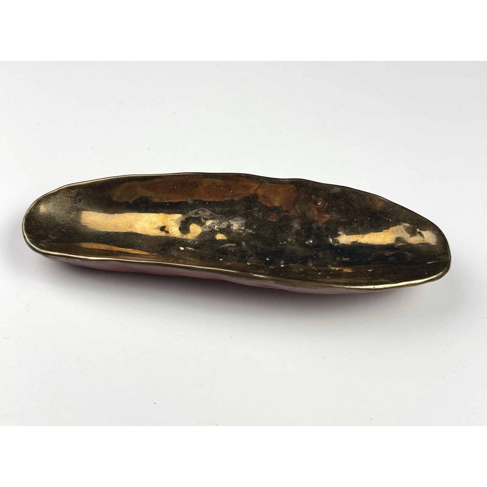 Artistic bronze-leaf base flowing under abstract glass form