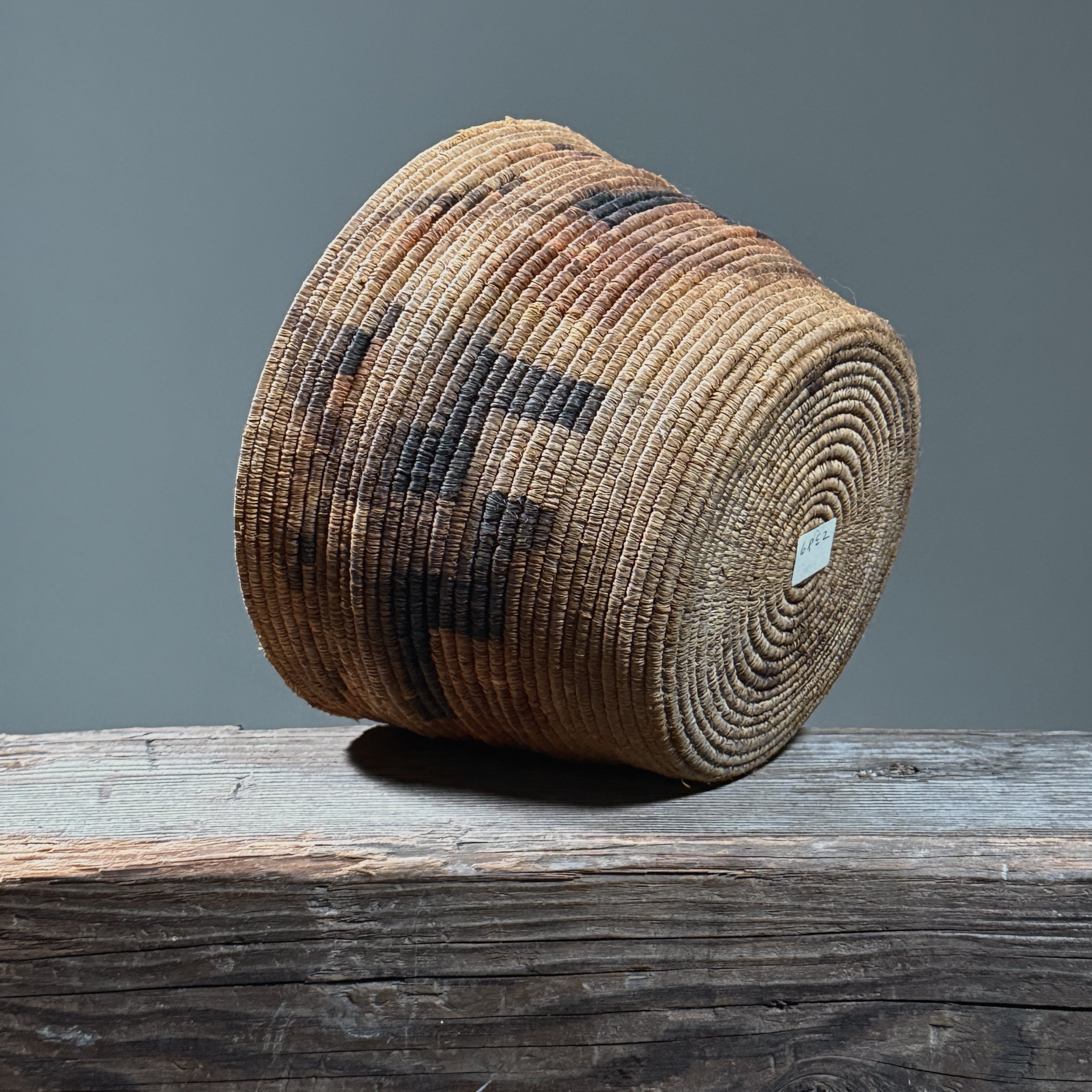 Full frontal view of an antique Tohono O'odham coiled basket with geometric step pattern