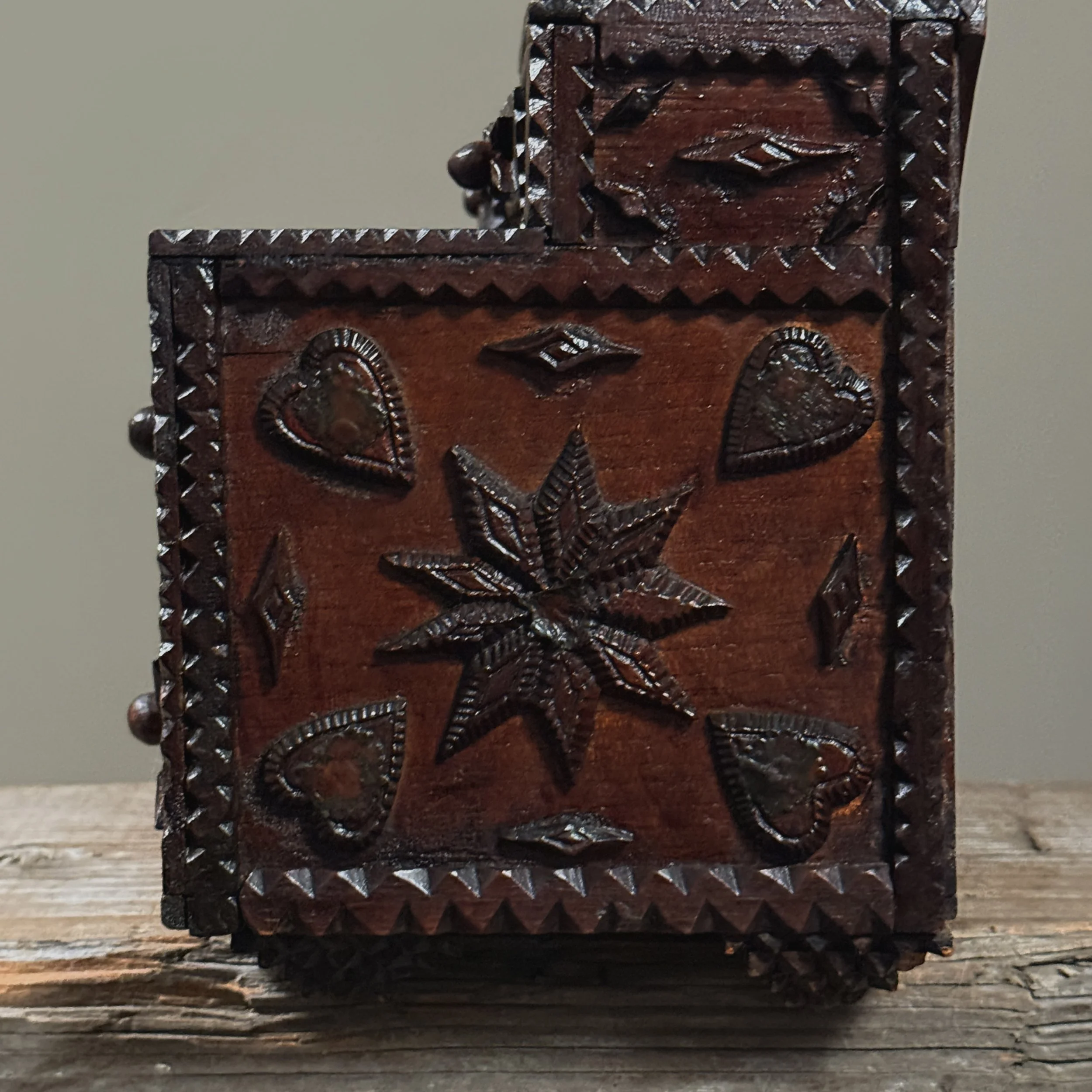 Close-up of layered chip-carving along the dresser’s surface