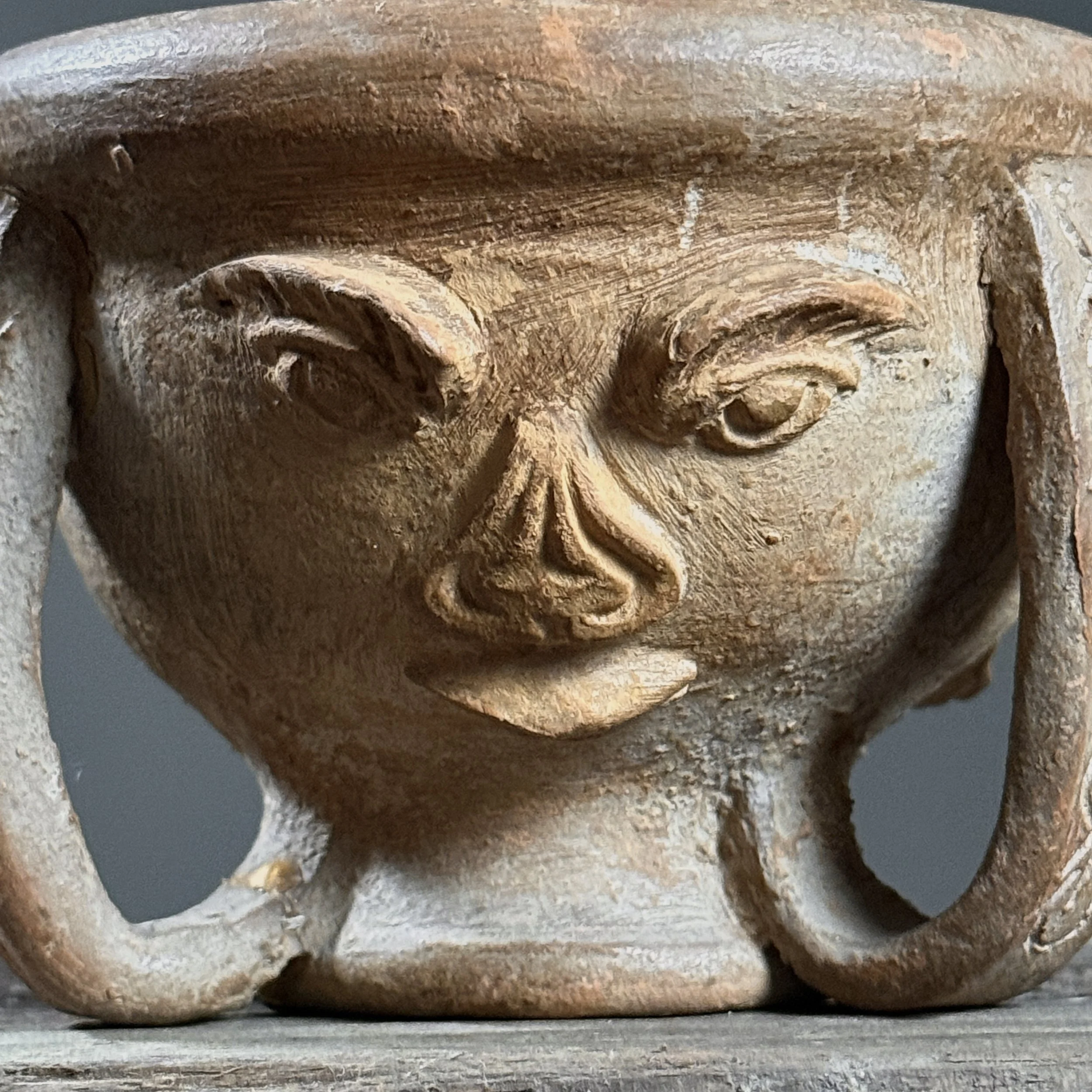 Close-up of carved portrait. Hand built clay. Folk art style.