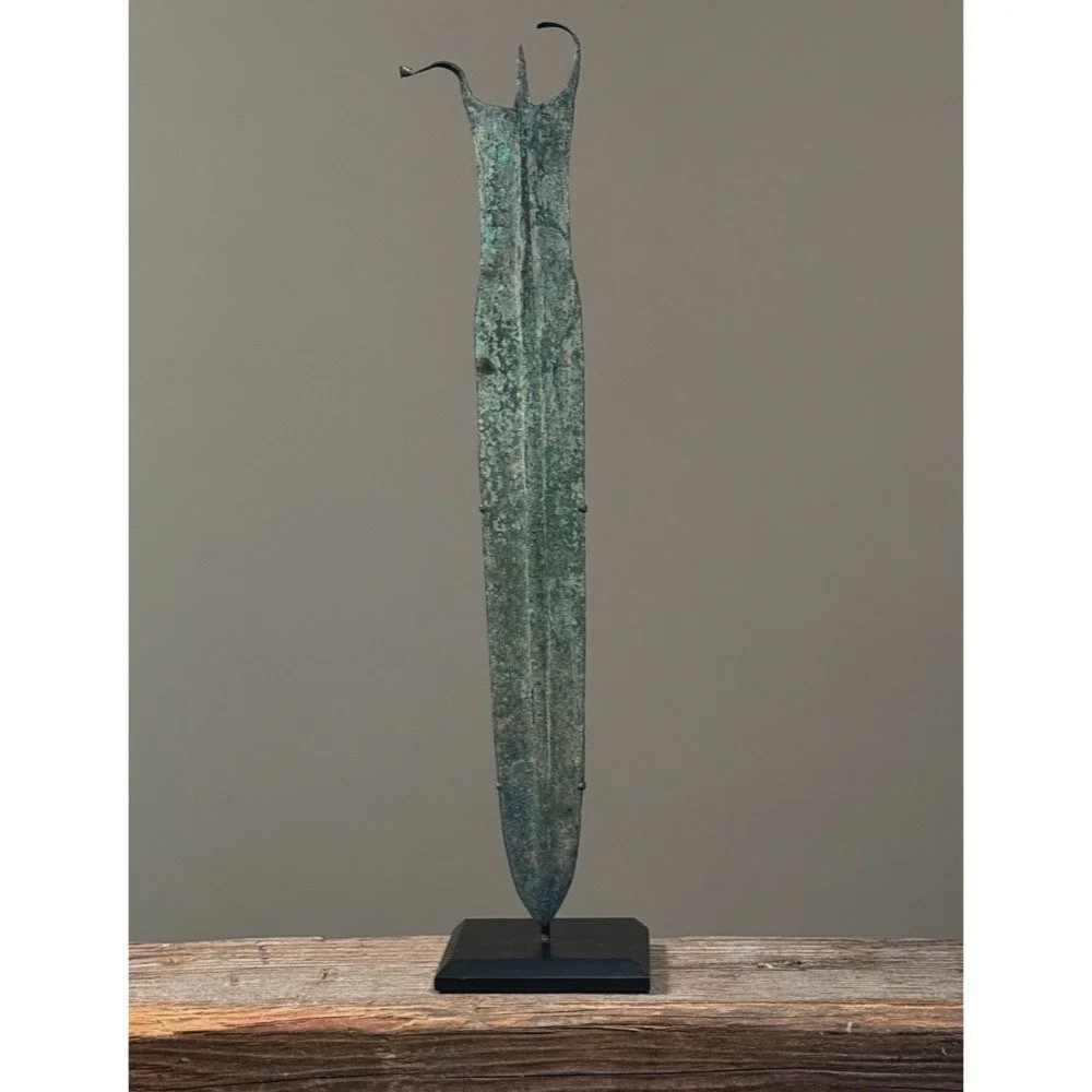 An ancient Luristan bronze dagger mounted on a custom metal display stand.