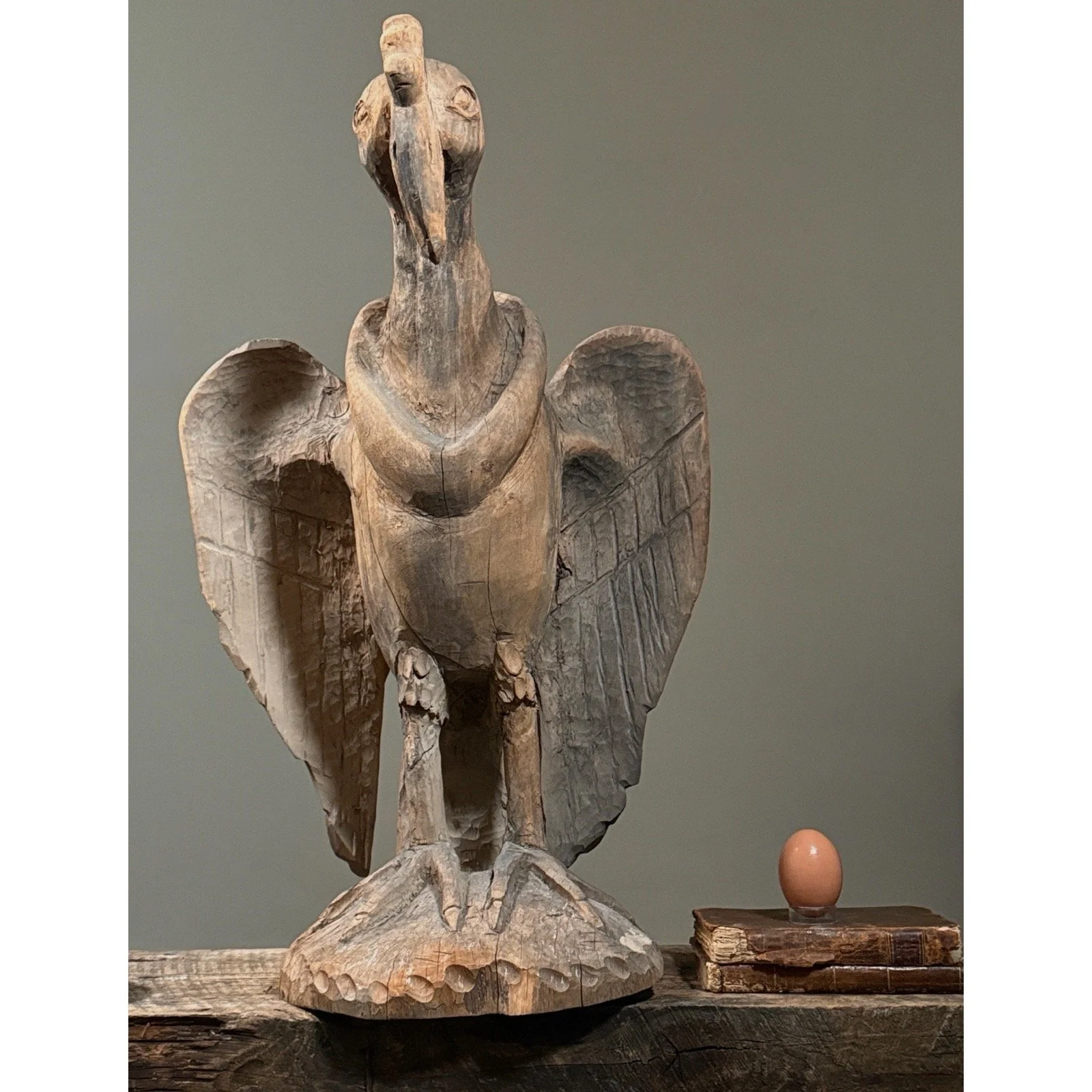 American folk art hand carved bird statue with egg for size reference.