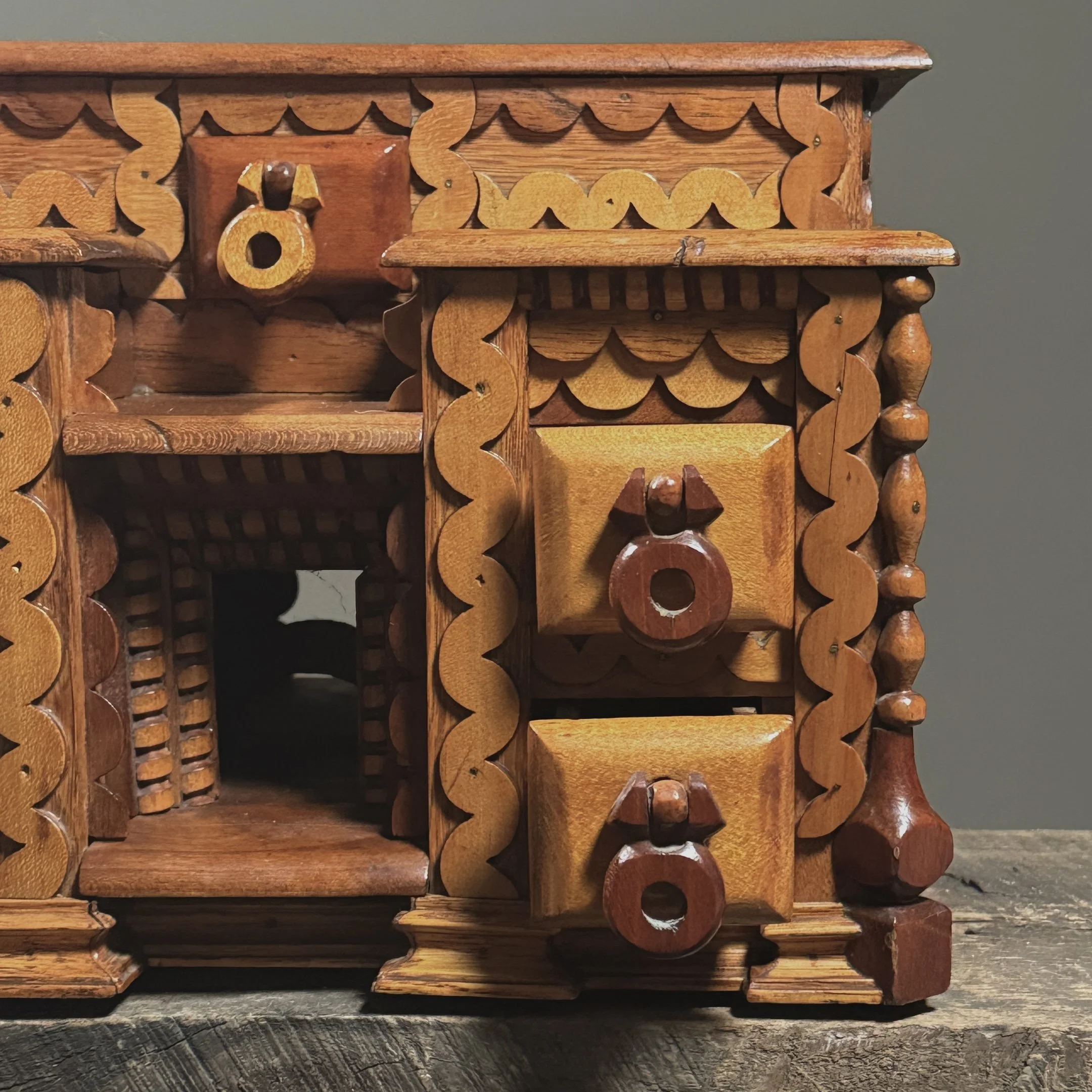 Close-up detail of layered "squiggly" scrollwork ornamentation on a vintage folk art box