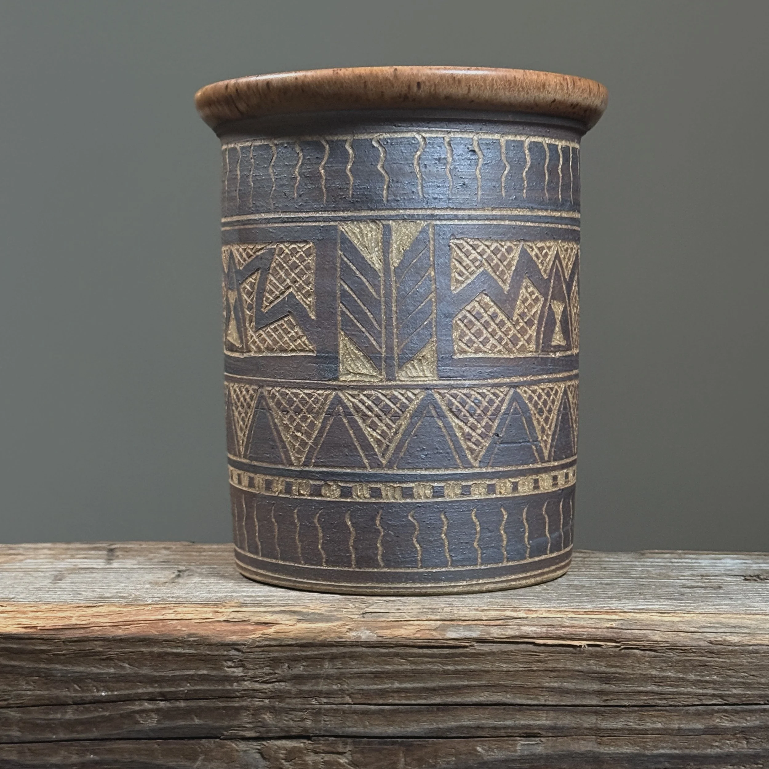 Full frontal view of a vintage sgraffito ceramic vase with geometric folk art design.