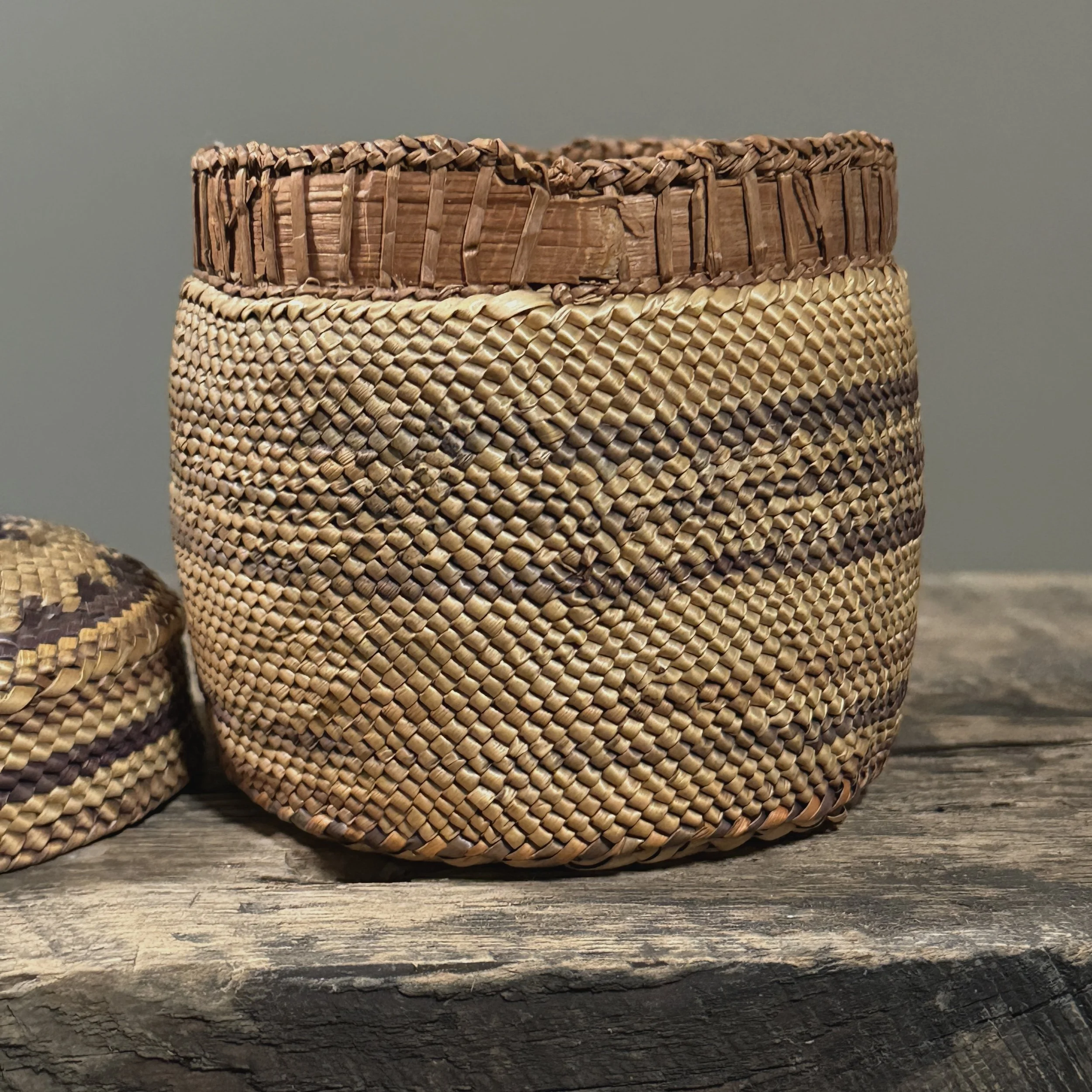 Close-up detail of wrapped twining technique and purple-dyed grass on an antique Makah basket