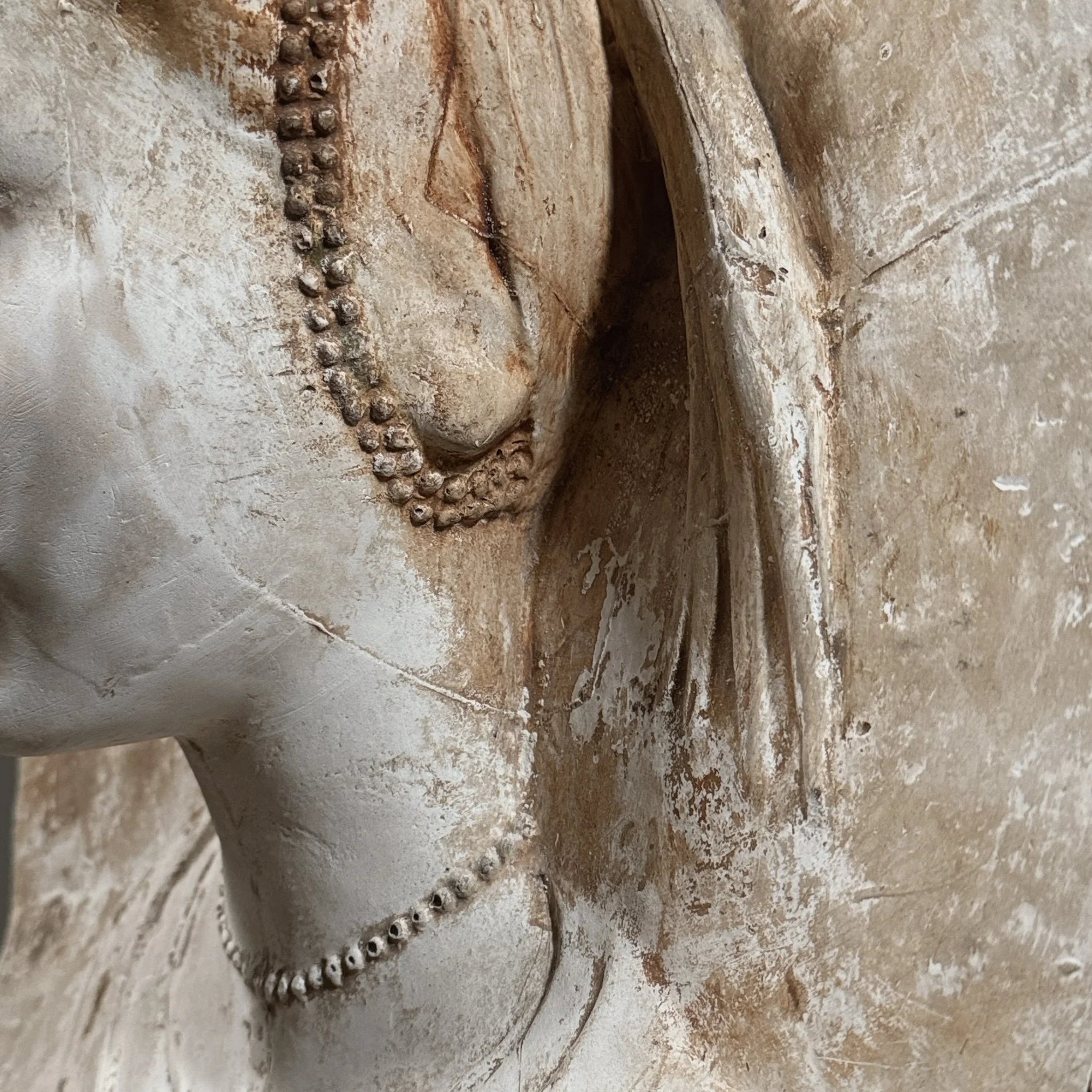 Detail of the female face, hair, and draped headdress.