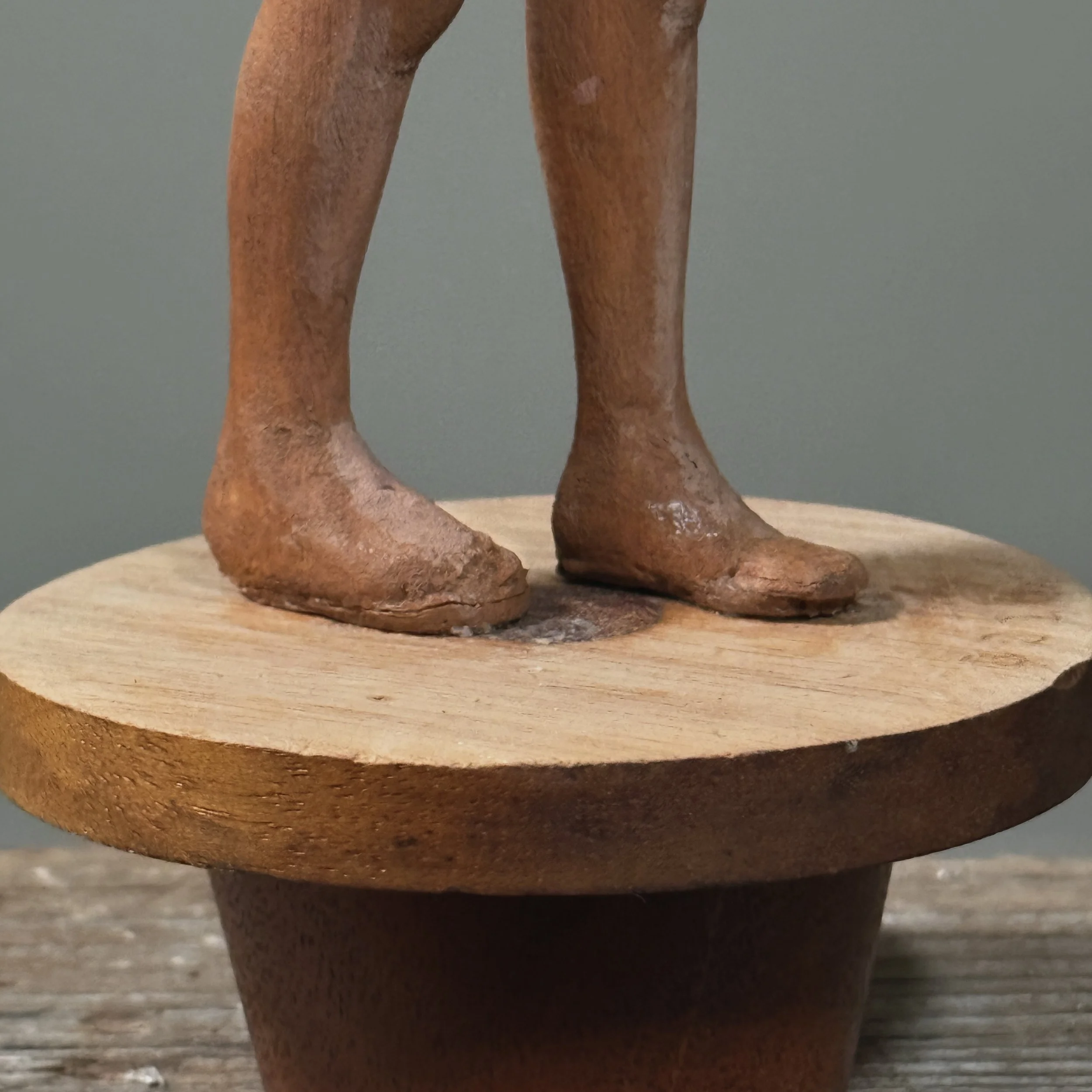Folk art figurative sculpture highlighting carved form and patina