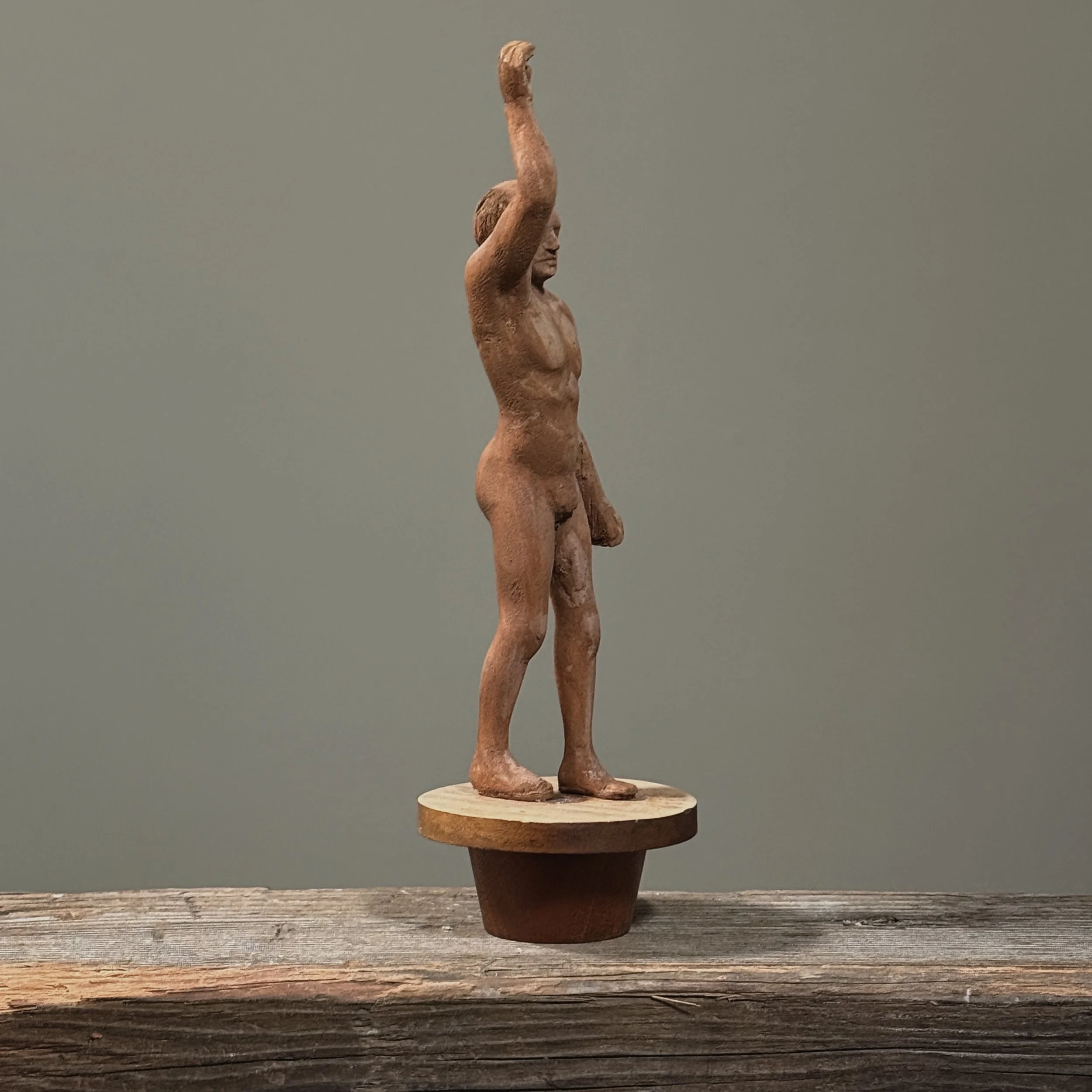 Vintage folk art sculpture with tapered wooden stand side view