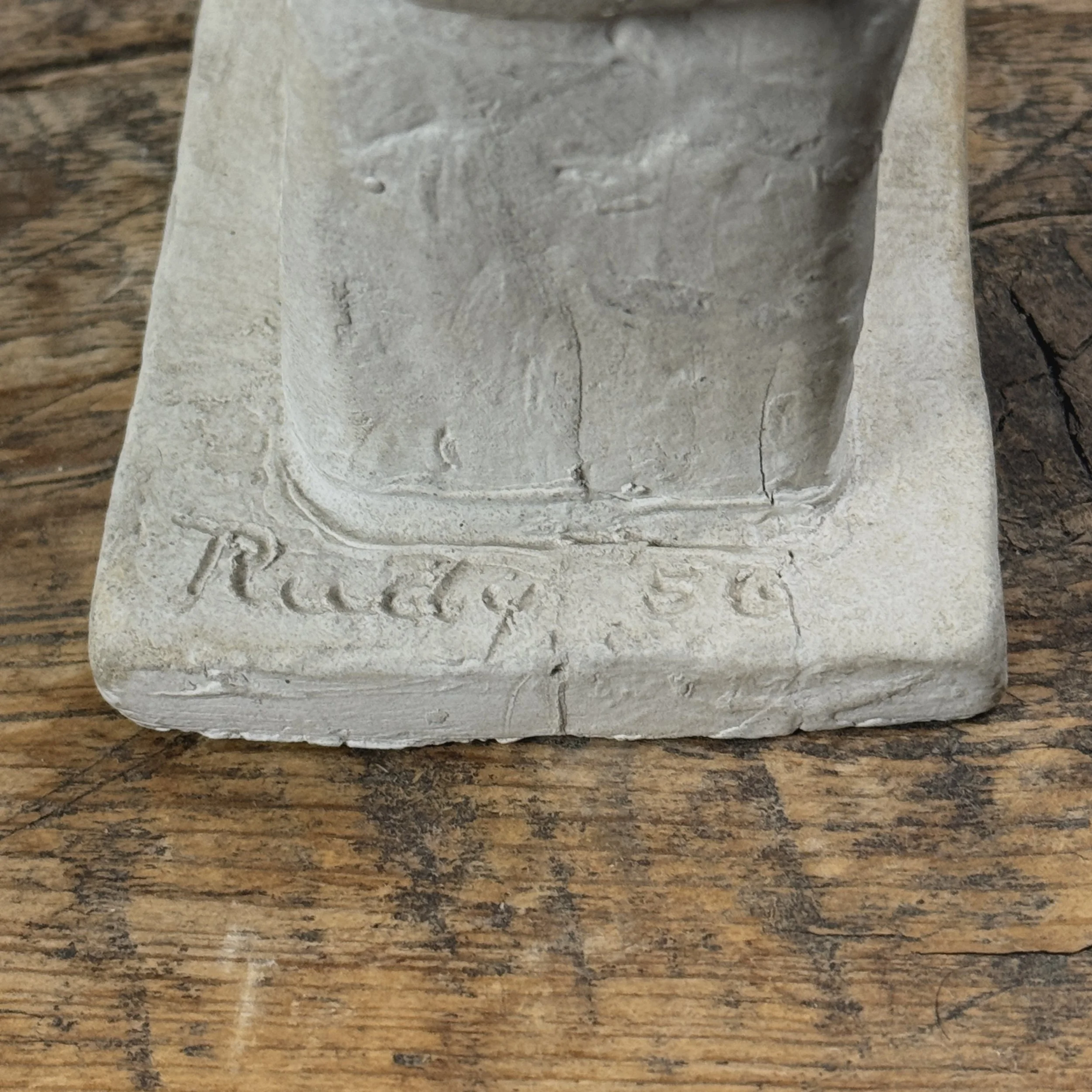 Back of statue. Signature "Rudy" visible.