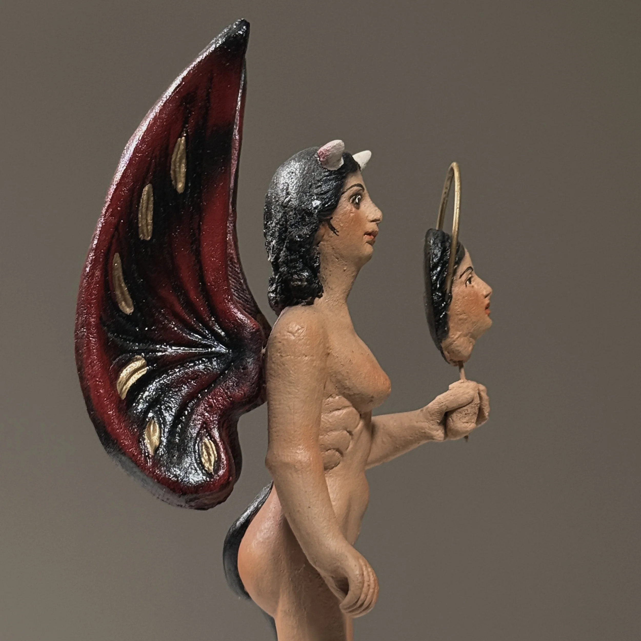 Close-up of face. Devil or angel expression. Polychrome decoration.