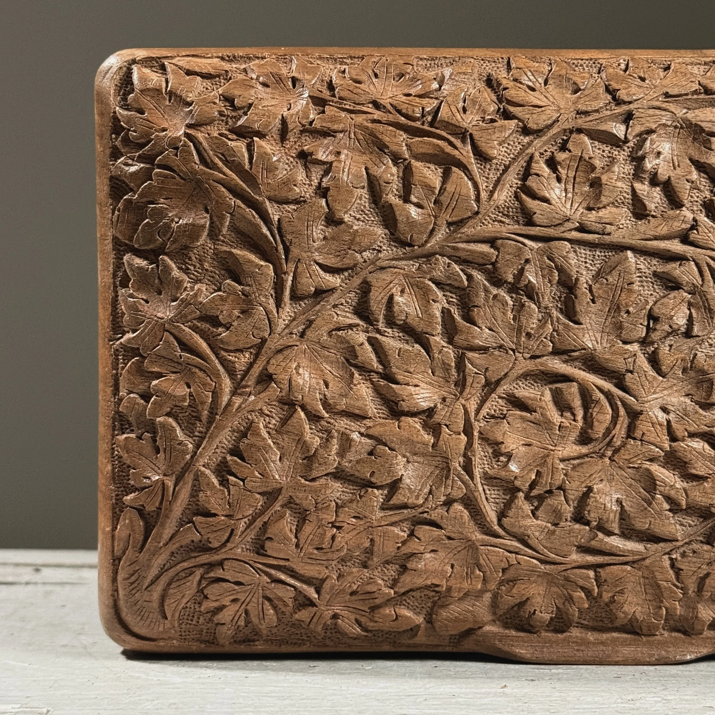 Macro detail of the chip-carving technique visible in the foliage pattern