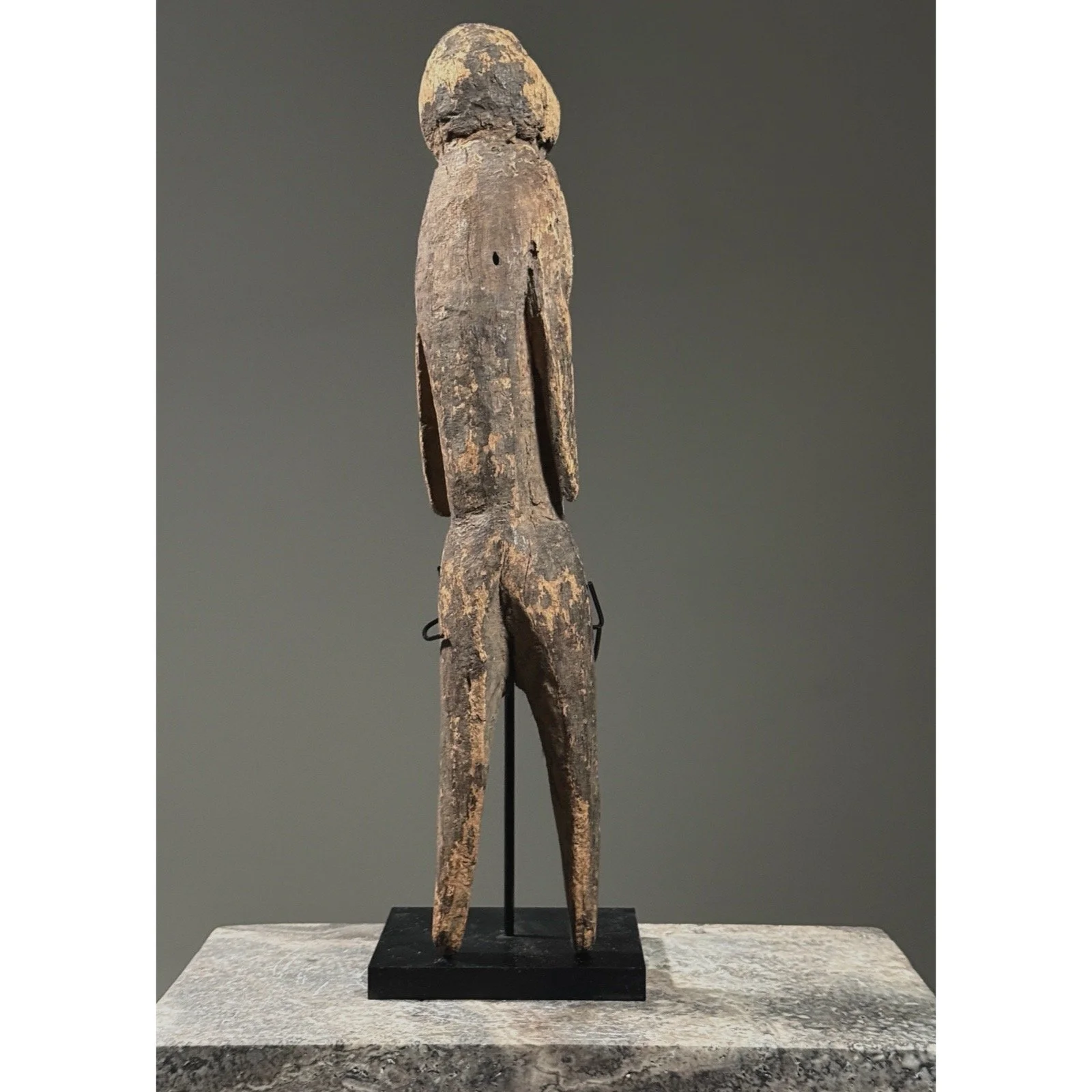 Rear view of a Moba tchitcheri figure showing hand-carved construction from a single piece of wood