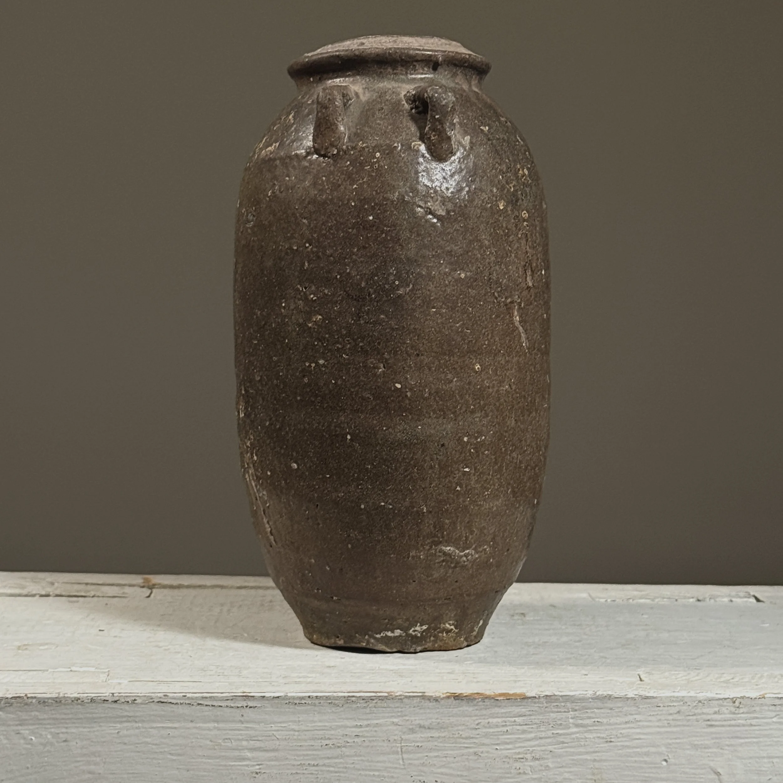 Full view of a 17th-century Vietnamese brown-glazed stoneware jar with lug handles.