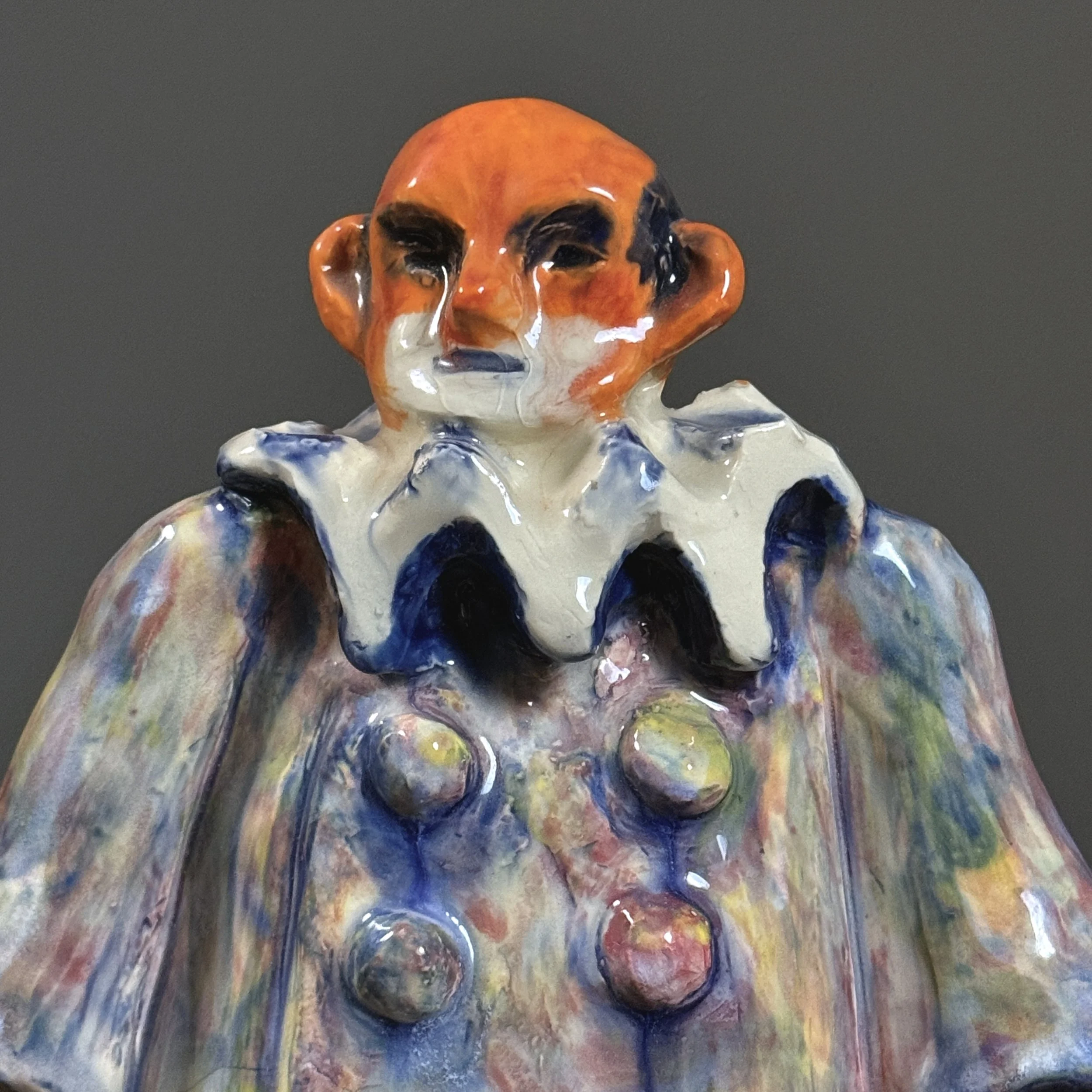 Detail view of the clown's face, highlighting the exaggerated, emotive modeling of the features.