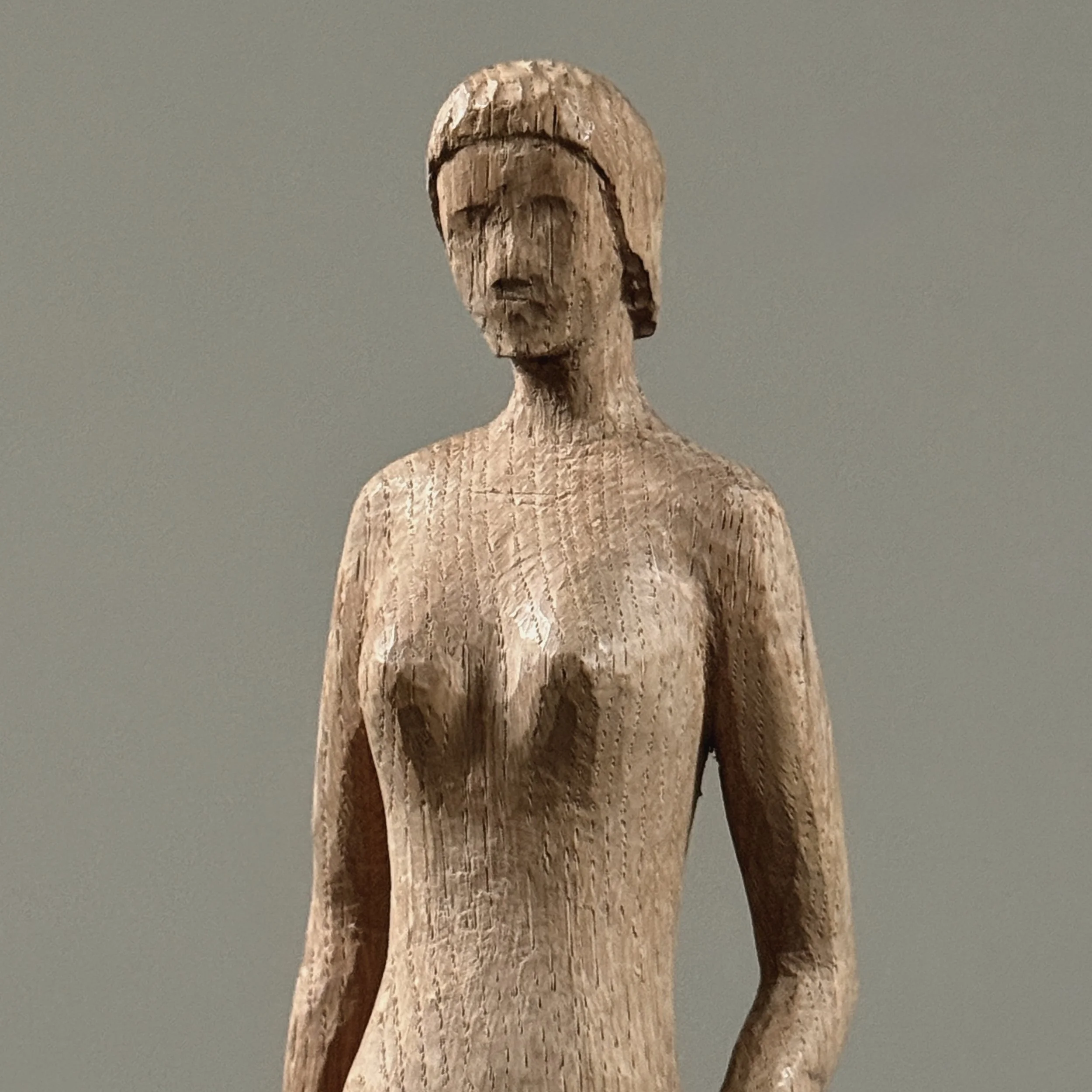 Detail of face and upper torso of vintage hand carved Danish modernist female nude sculpture, wood