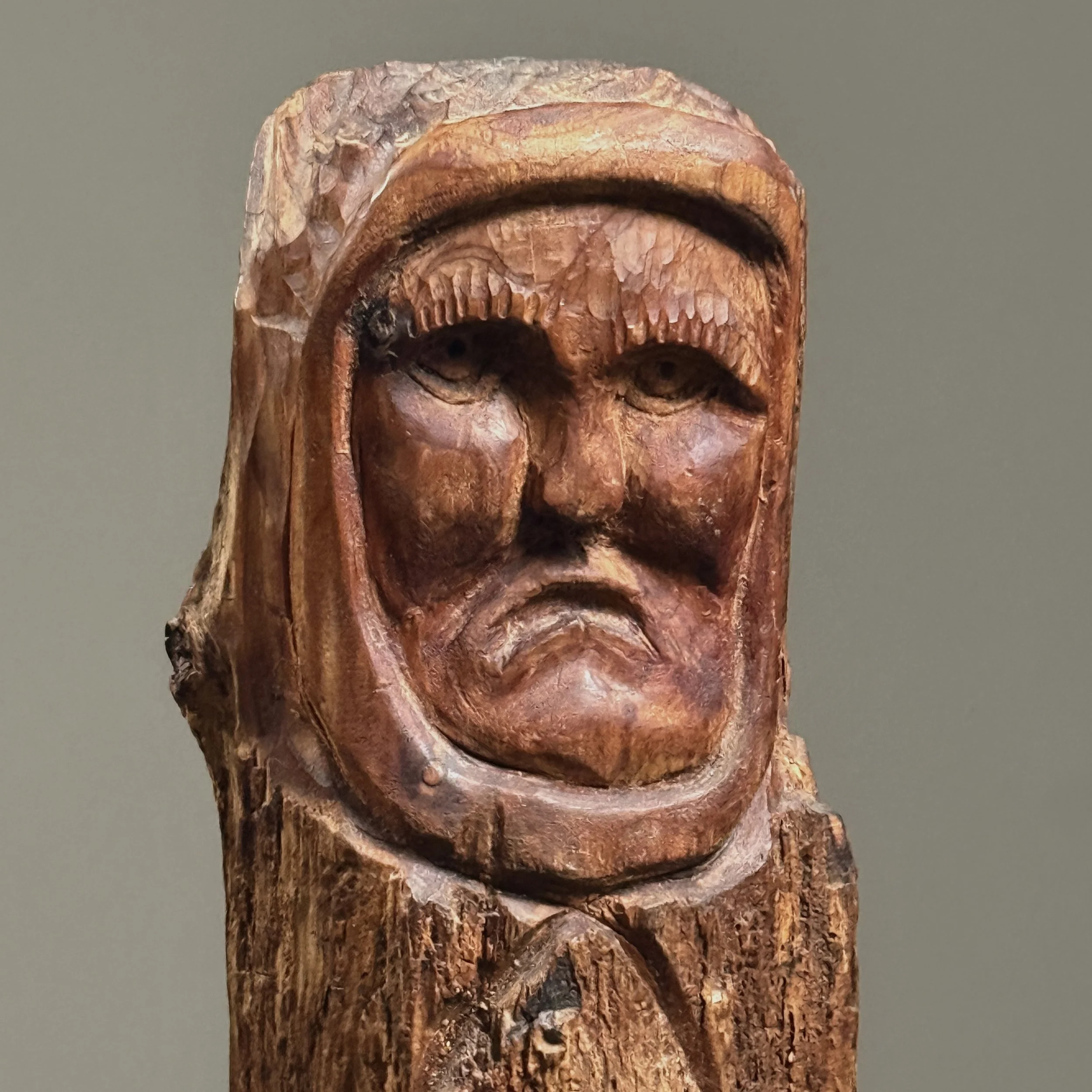 Portrait carved in tree branch, stylized visage, folk art sculpture