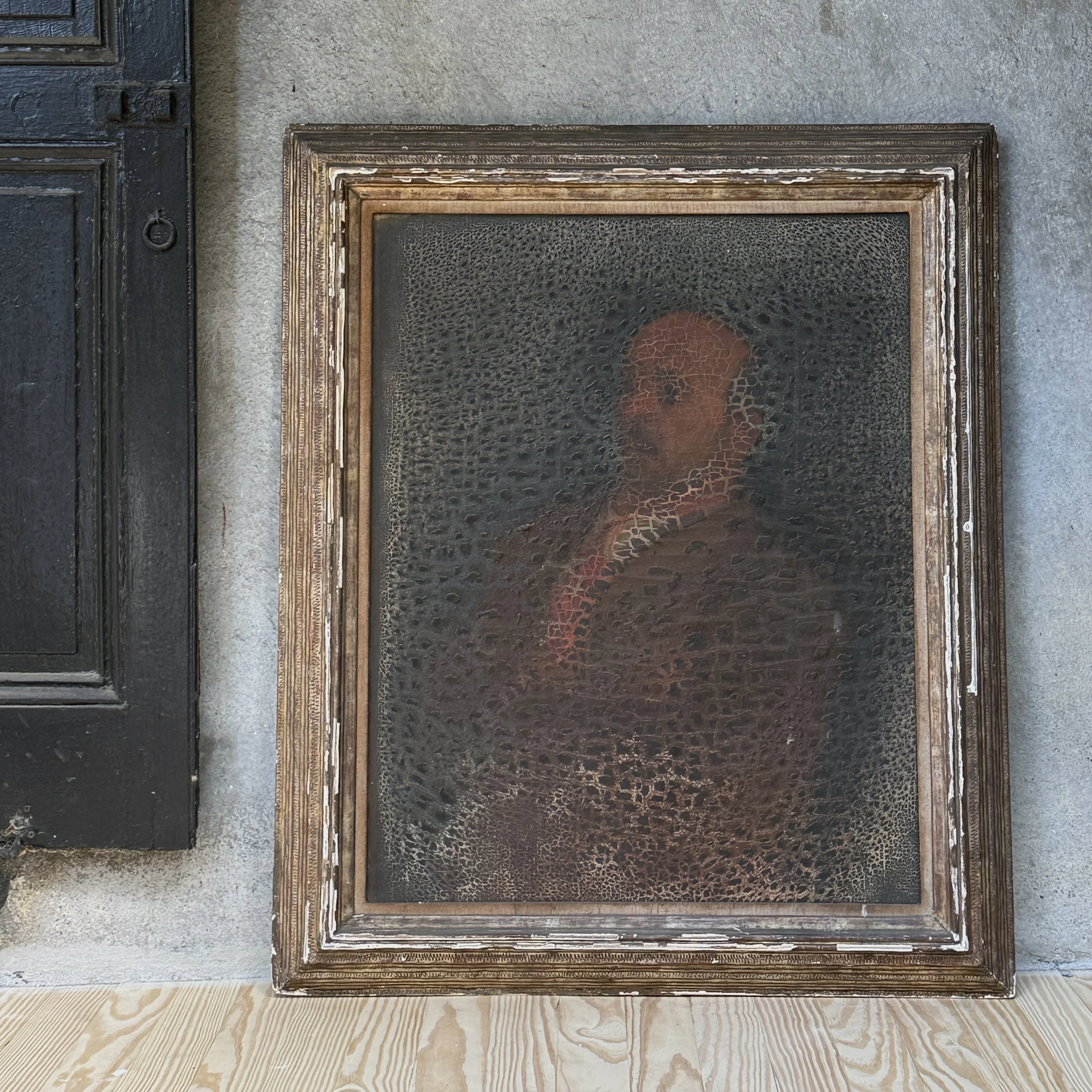 Full frontal view of a 19th-century oil portrait of a seated man in red, in a carved wood frame.