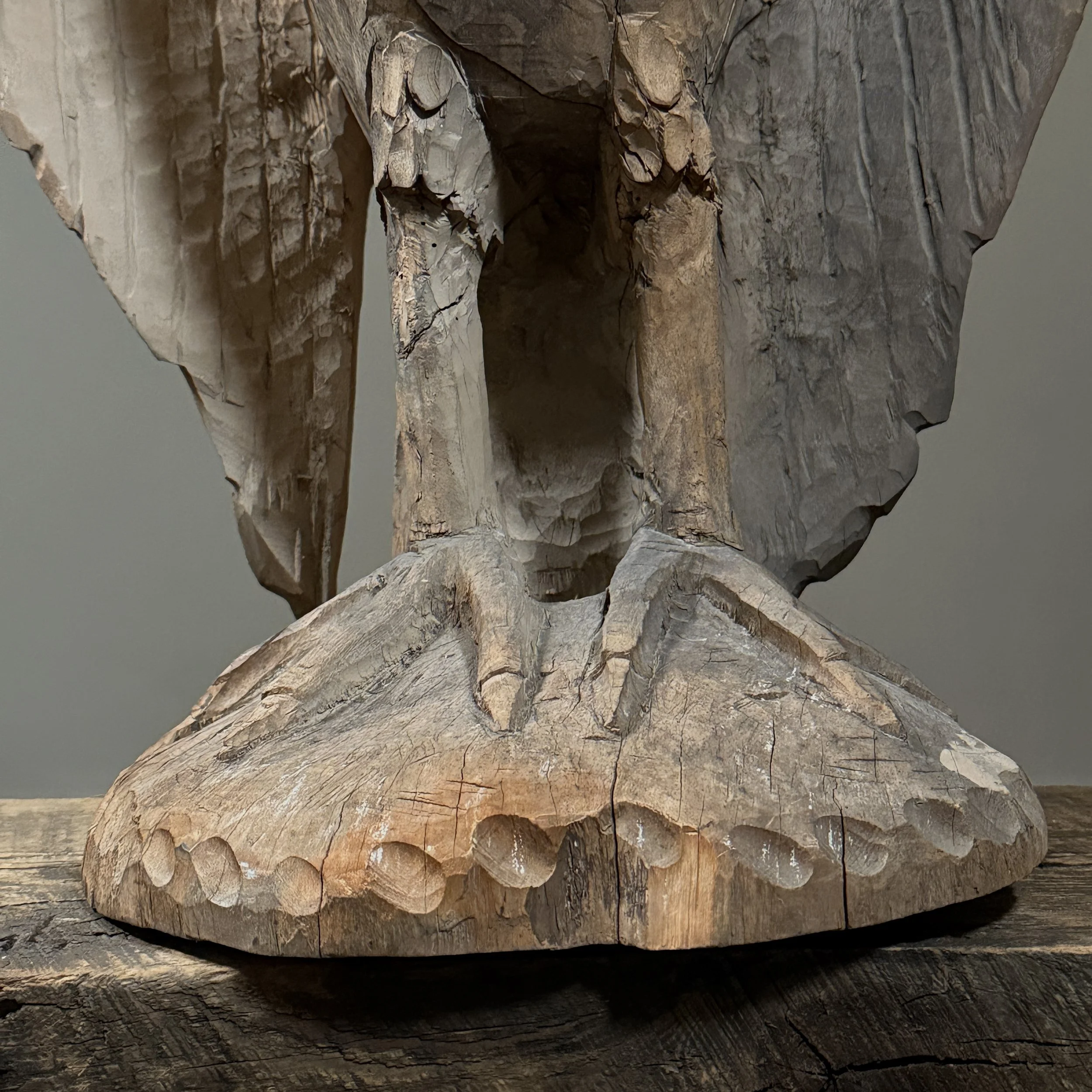 Rustic hand carved bird sculpture aged wood surface