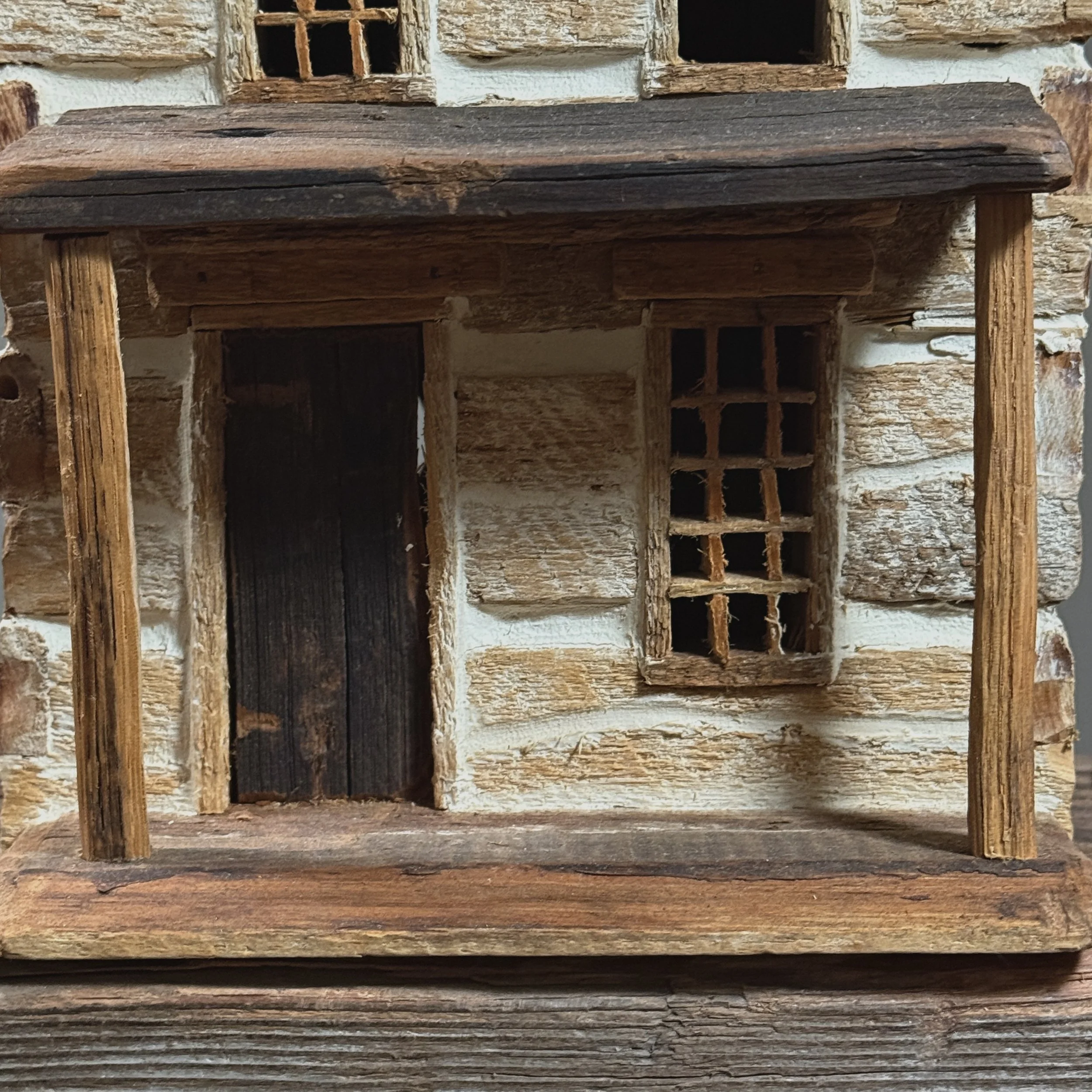 Detail view of handcrafted windows on vintage Americana country house model.