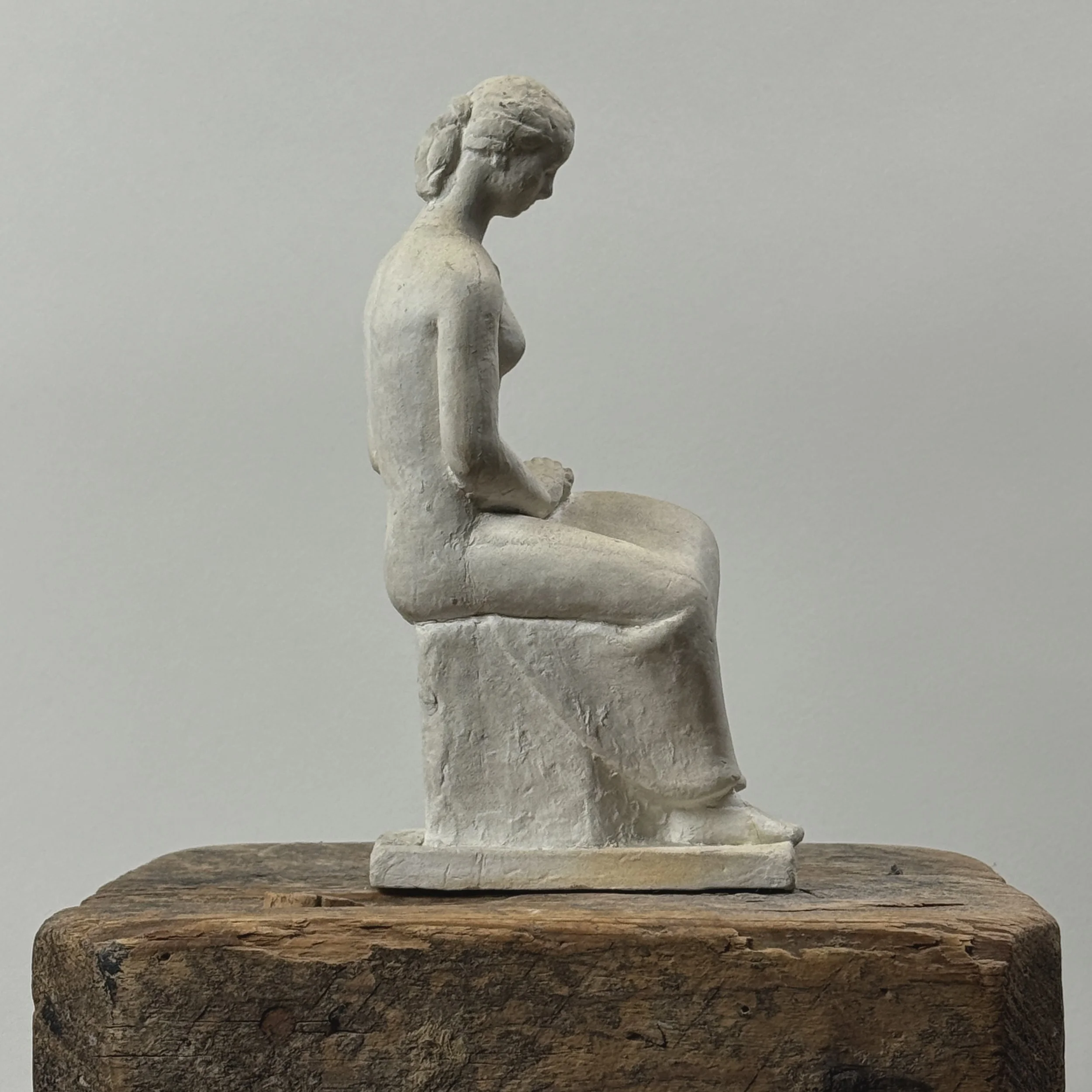 Vintage painted plaster statue of seated woman. Signed Rudy on back. 8.25 inches high.